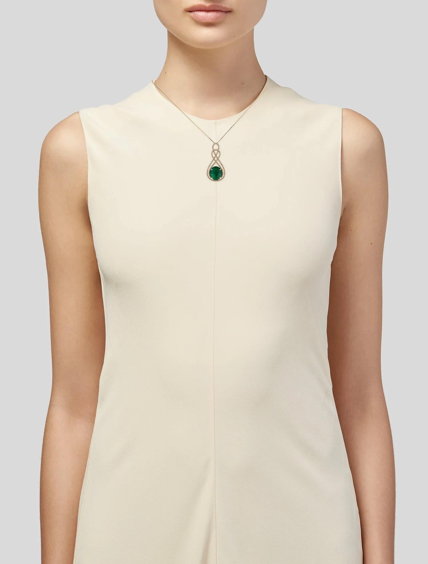 Ce collier pendentif en or jaune 14 carats est une déclaration d'élégance intemporelle, avec comme pièce maîtresse une impressionnante émeraude ovale cabochon de 15,92 carats. La riche émeraude verte est complétée par 1,29 carats de diamants quasi