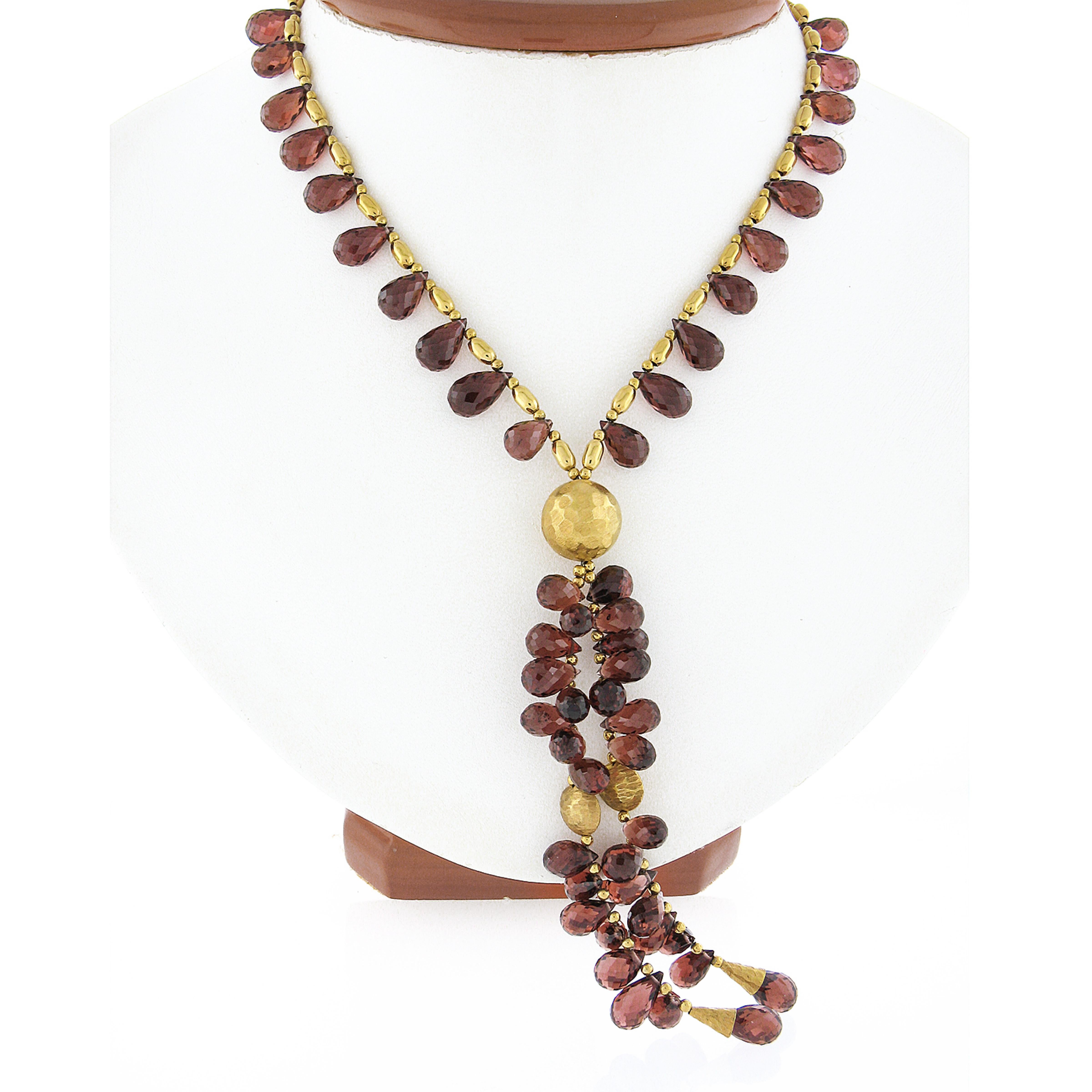This gorgeous garnet bead necklace was crafted from solid 14k yellow gold. The necklace features polished and hammered finish gold beads that are wire strung with numerous tear drop shaped briolette cut garnet beads throughout. Those stones display