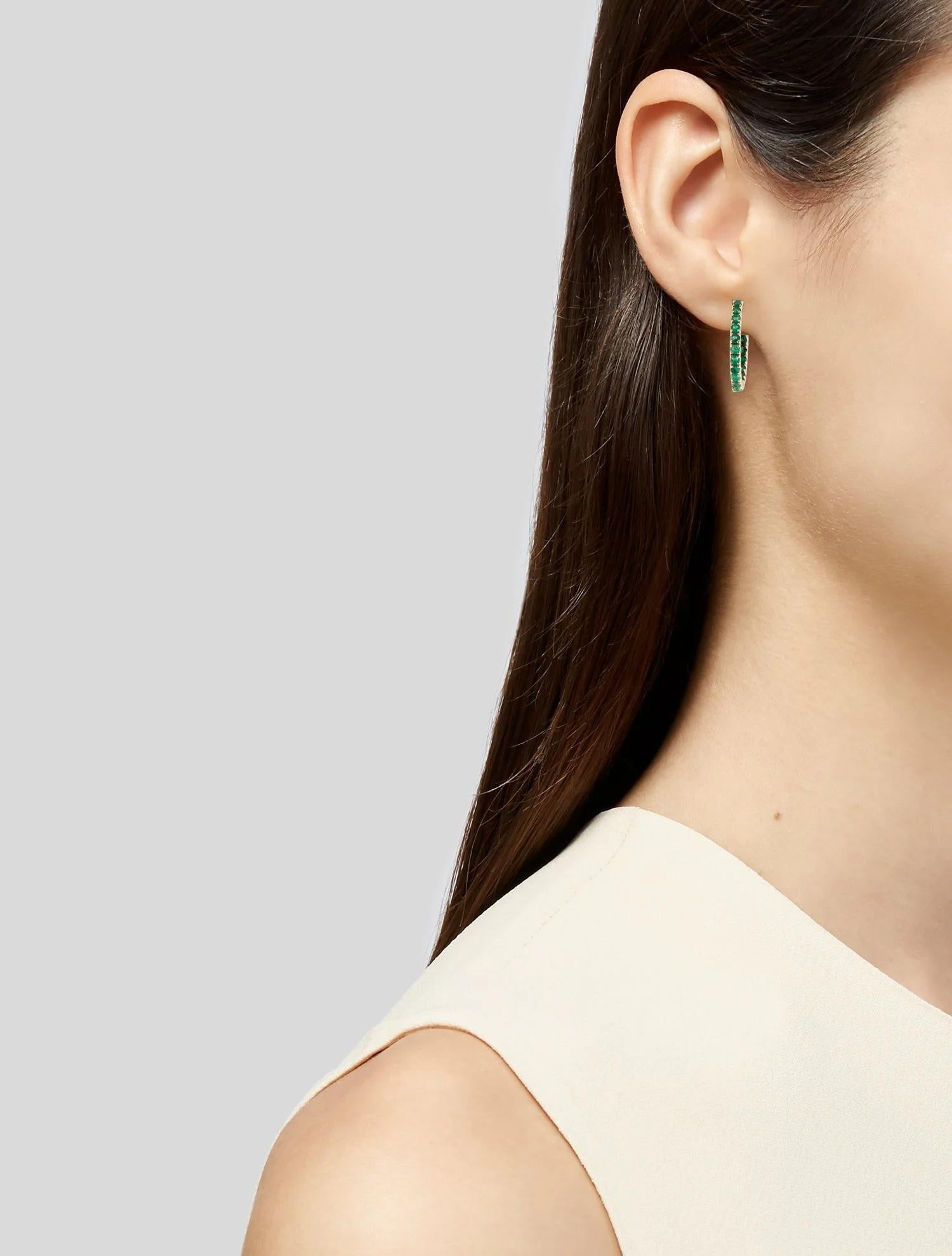 These elegant 14K Yellow Gold Inside-Out Hoop Earrings feature a stunning array of 1.79 carats of faceted round emeralds. The vibrant green emeralds are meticulously set along the inner and outer edges of each hoop, creating a captivating sparkle