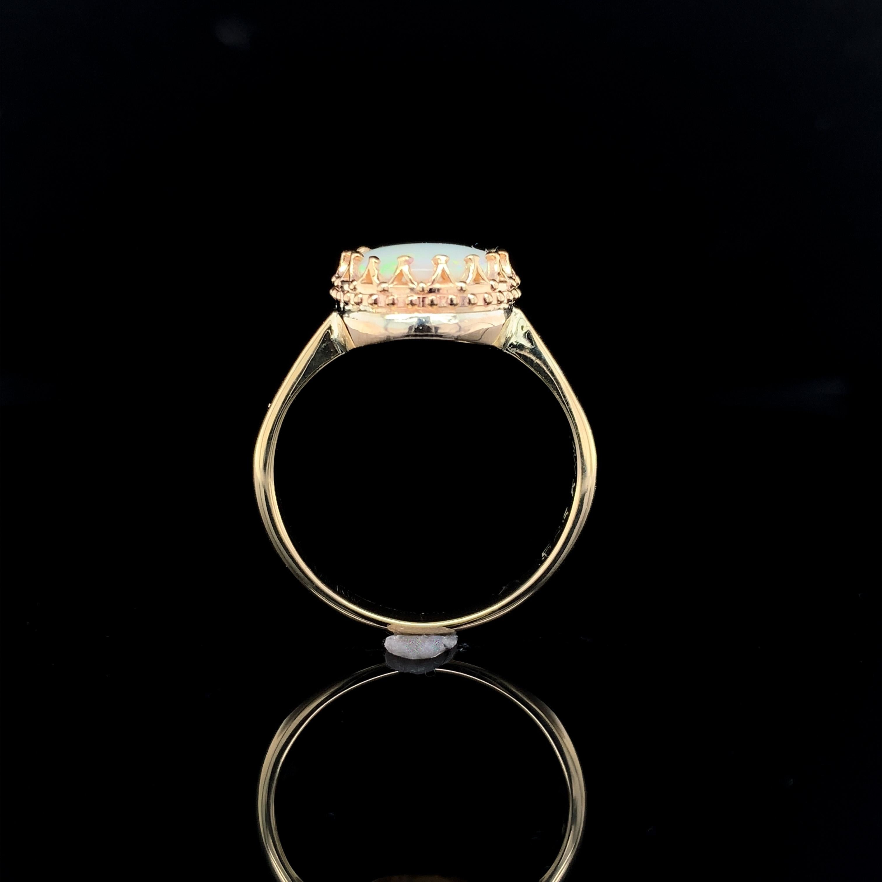 Vintage 14K yellow gold 1.80 carat opal ring. The genuine natural Australian opal measures about 11mm x 8.5mm. The opal is translucent and has primarily green play of color. The ring has evidence of a little hand engraving on the sides, engraving is