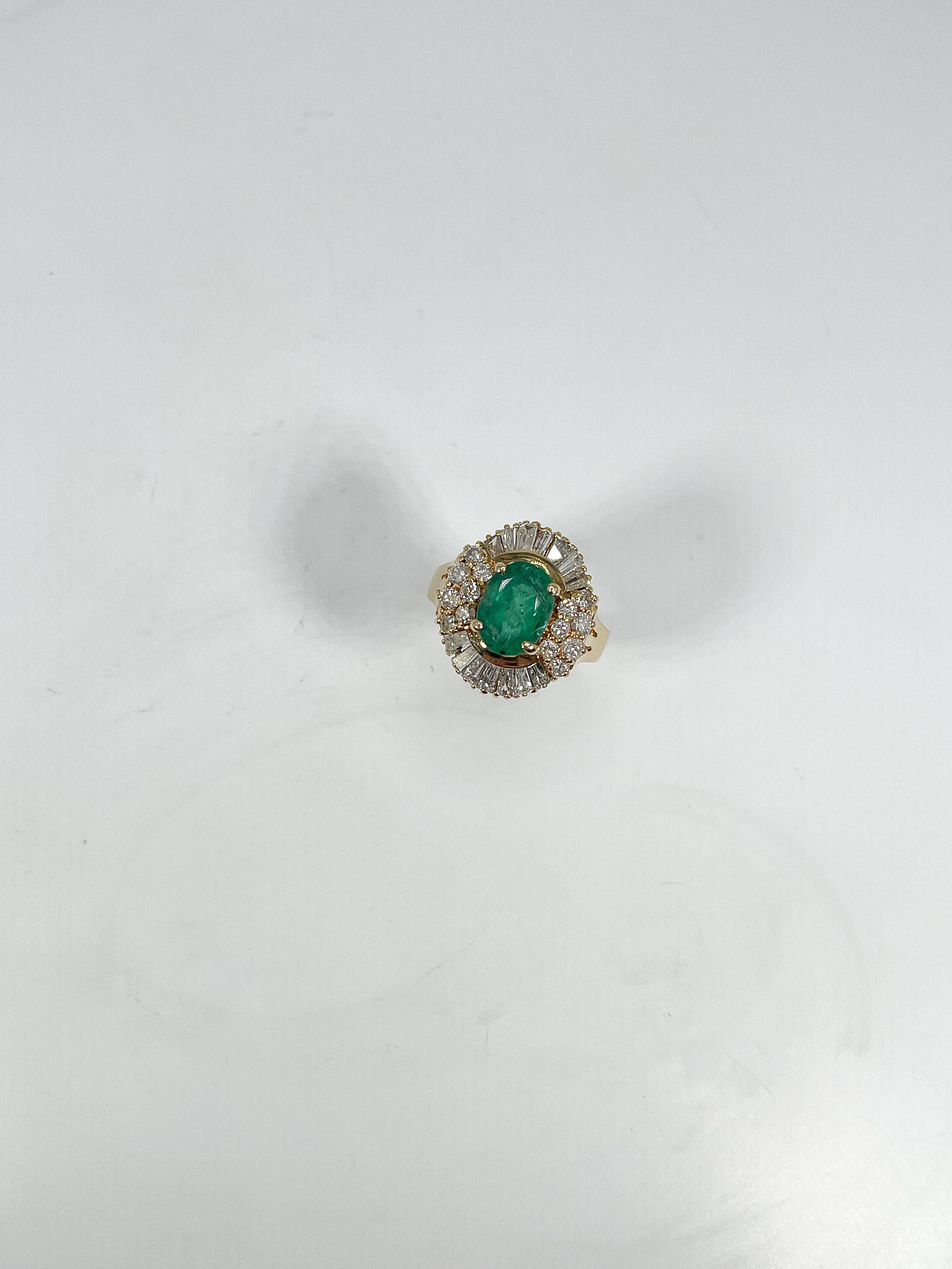 14k yellow gold 2 CT emerald and 1 CTW diamond ballerina ring. The emerald is an oval, the diamonds are round and baguette, the size of the ring is a 6, the width is 17 mm, and it has a total weight of 5.8 grams.