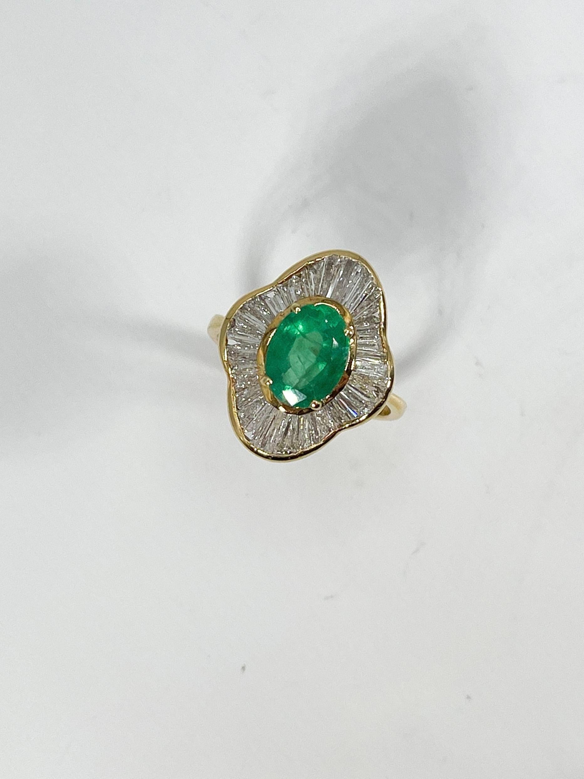 14k yellow gold 2 CT oval emerald and 1 CTW diamond ballerina ring. The emerald is an oval, the diamonds are all baguettes, the size of the ring is a 6 1/4, and it has a total weight of 5.2 grams.