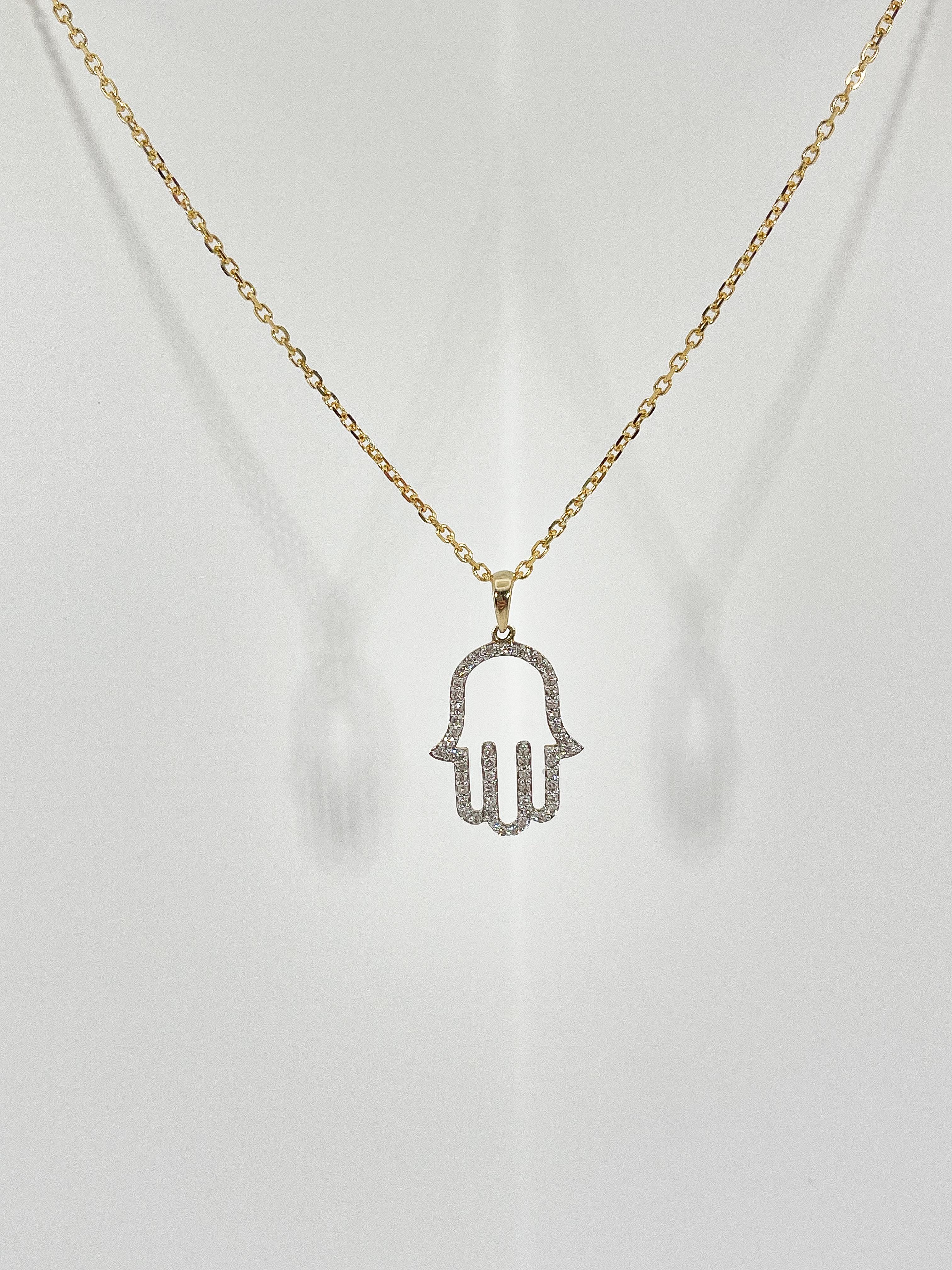 14k yellow gold .21 CTW diamond hamsa necklace. The  pendant comes on a cable chain, the diamonds in the pendant are all round cut, the length of the necklace is 16 inches, measurements of the pendant are 17.5 x 13.5 mm, and the necklace has a total