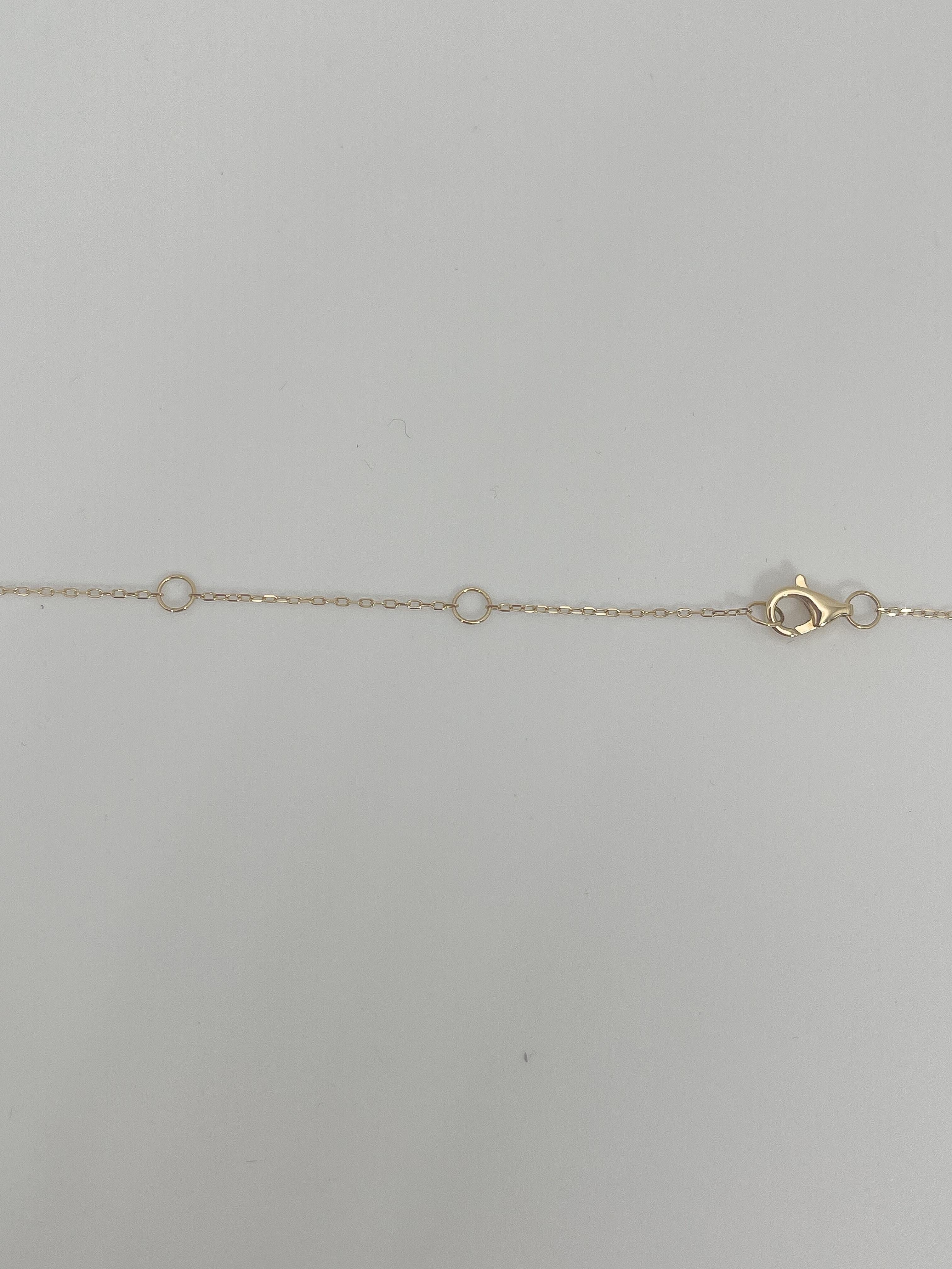 14k yellow gold .22 CTW diamond cross pendant necklace with diamond stations. The necklace measures to be 16'' with an extension at 17'' and 18'', the pendant measures 15mm x 10.5mm, the diamond stations have a diameter of 2.5mm, all diamonds in