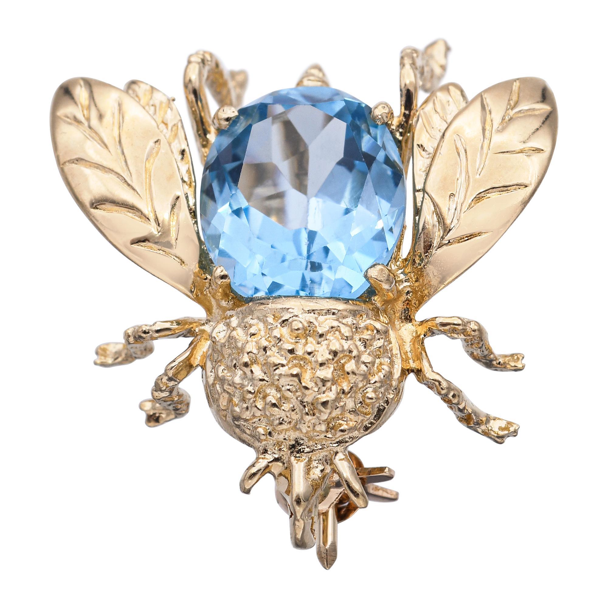 This vintage bumblebee brooch pendant is crafted in 14k yellow gold and features a striking 2.4-carat aquamarine as its luminous centerpiece. The cool blue hue of the aquamarine contrasts beautifully with the warm gold, bringing a refreshing