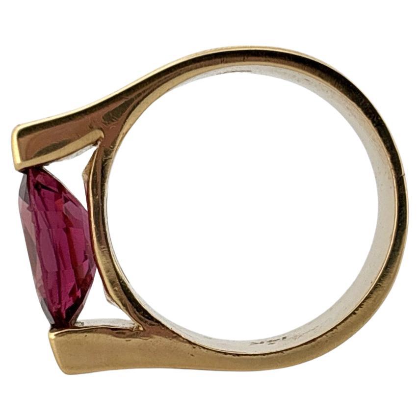 Cette bague frappante met en valeur l'élégance moderne avec son design architectural audacieux. Réalisée en or jaune 14 carats, cette bague est ornée d'une tourmaline rose ovale de 2,50 carats, solidement maintenue dans une élégante monture à