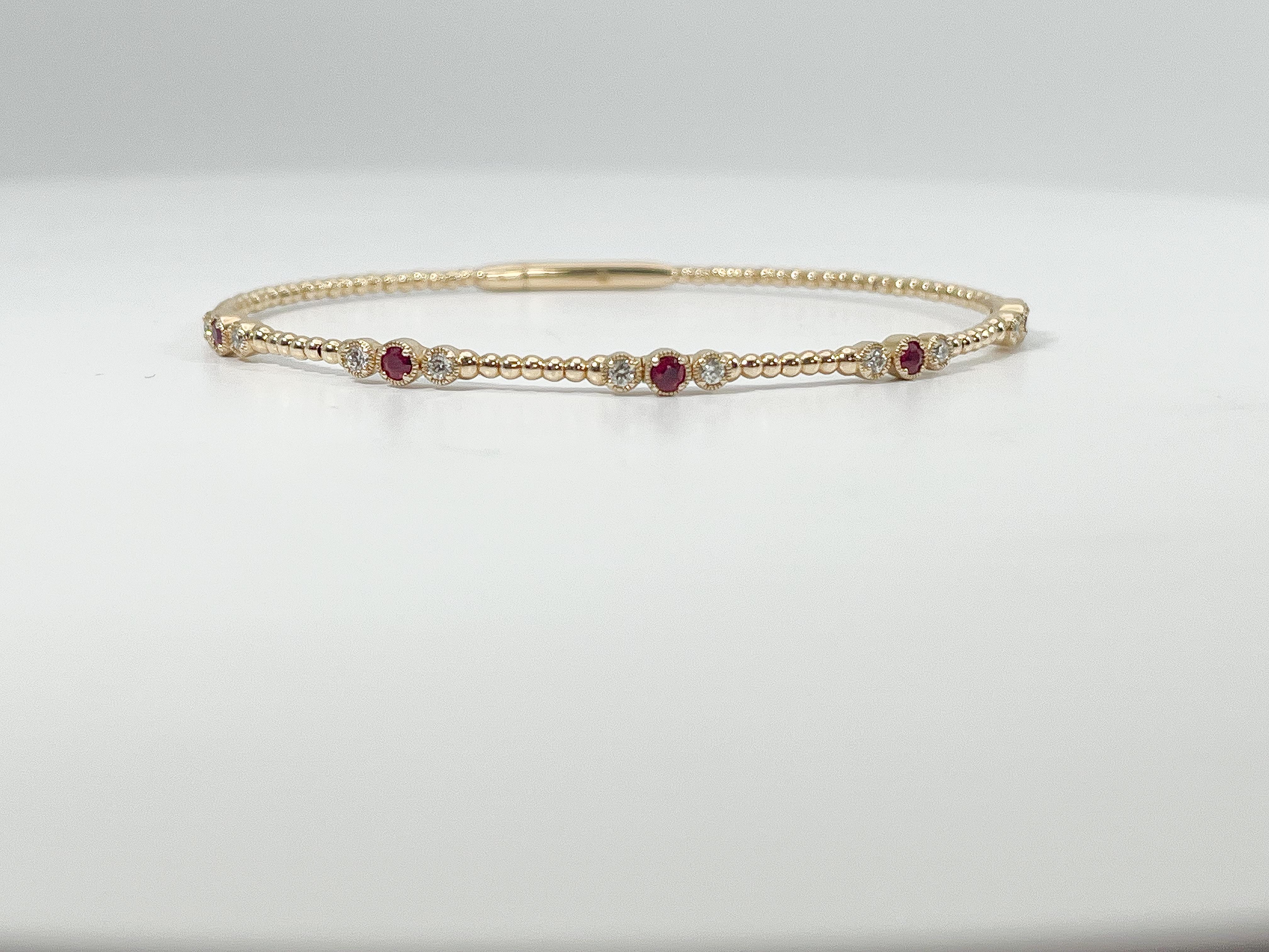 14K Yellow Gold .25CTW Diamond and .29CTW Ruby Bangle. Bangle is 6