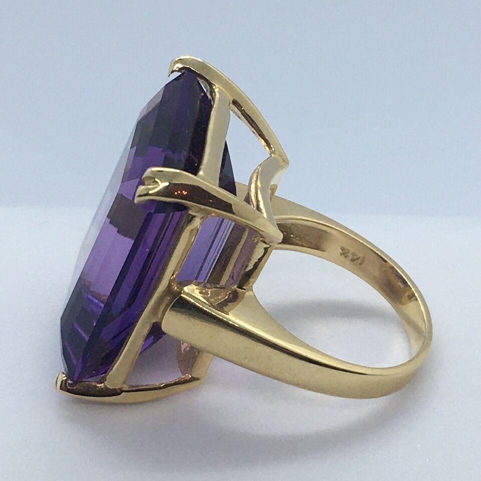 14 Karat yellow gold ring worked with one natural rectangular faceted Amethyst 19.5 mm by 23 mm, 10.5 mm depth no chips, no damage, weighting 15.3 gram finger size 7
14k Yellow Gold 28 Carat Rectangular Faceted Amethyst Lady's Ring
Finger Size: