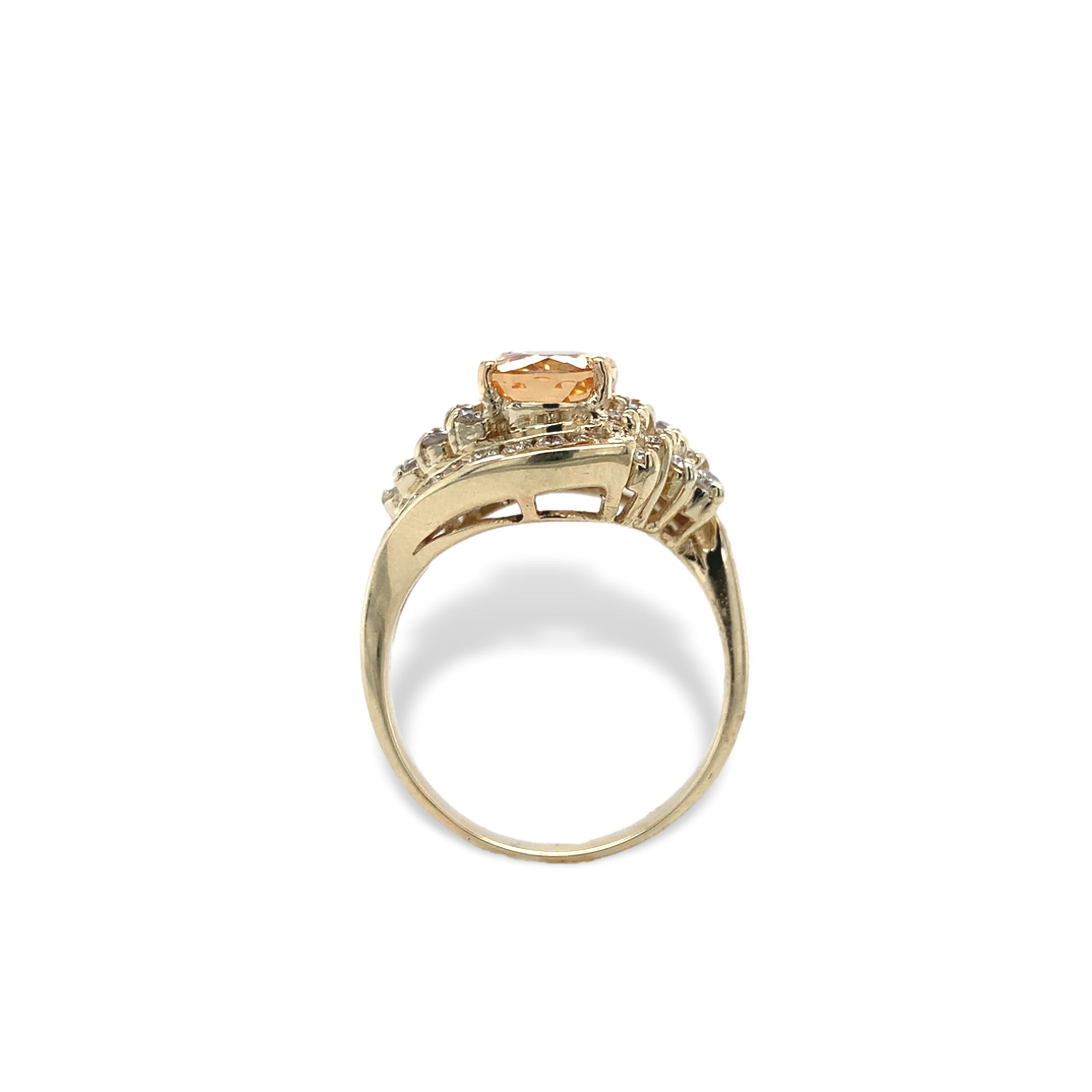 14K yellow gold ring featuring an oval precious topaz weighing 2.95 carats. The topaz is a warm golden color and measures about 9mm x 7mm. There are 38 round brilliant cut diamonds measuring about 1.8mm-1.9mm and weighing about 1 carat total. The