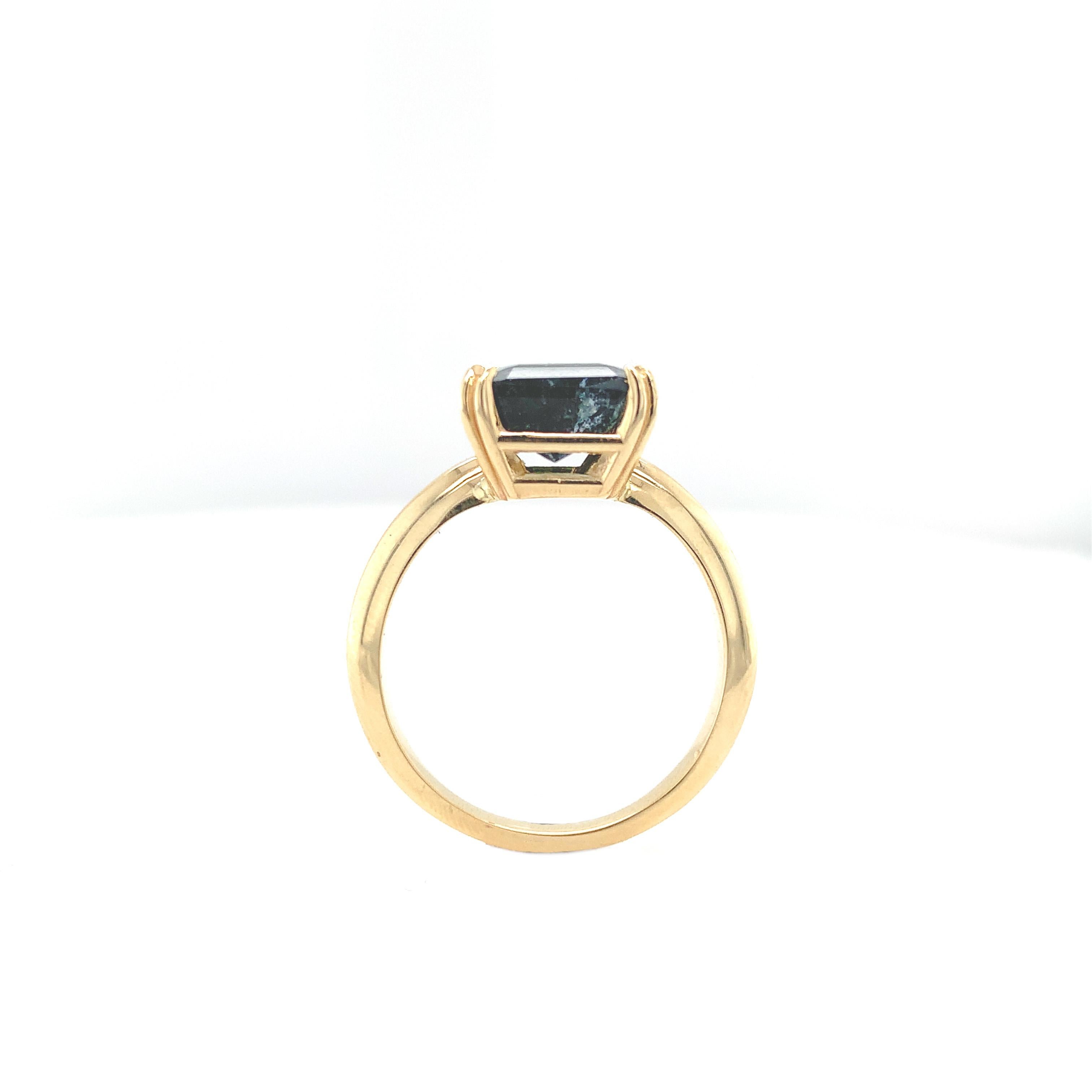 A 14K yellow gold ring featuring a bi-color tourmaline weighing 3.13 carats. The tourmaline has color from clear to green to very dark green, almost black. The tourmaline is an almost square step cut and measures about 8.5mm x 8mm. The tourmaline is
