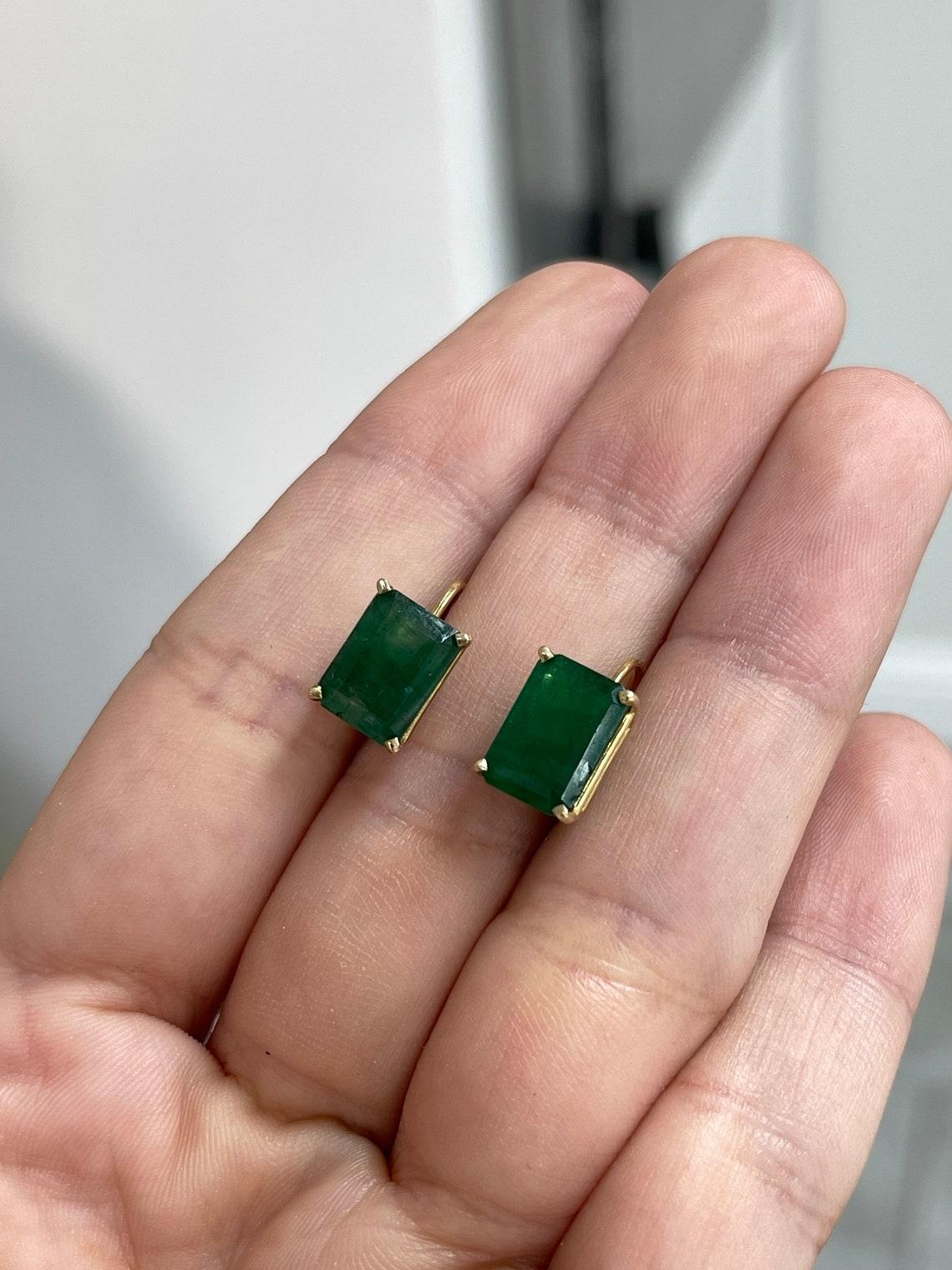 A gorgeous pair of emerald cut-emerald lever back earrings, hand-made in 14K yellow gold. The chic pair of lever back earrings feature green, natural emeralds. The emeralds have beautiful eye clarity with minor imperfections! The forest green