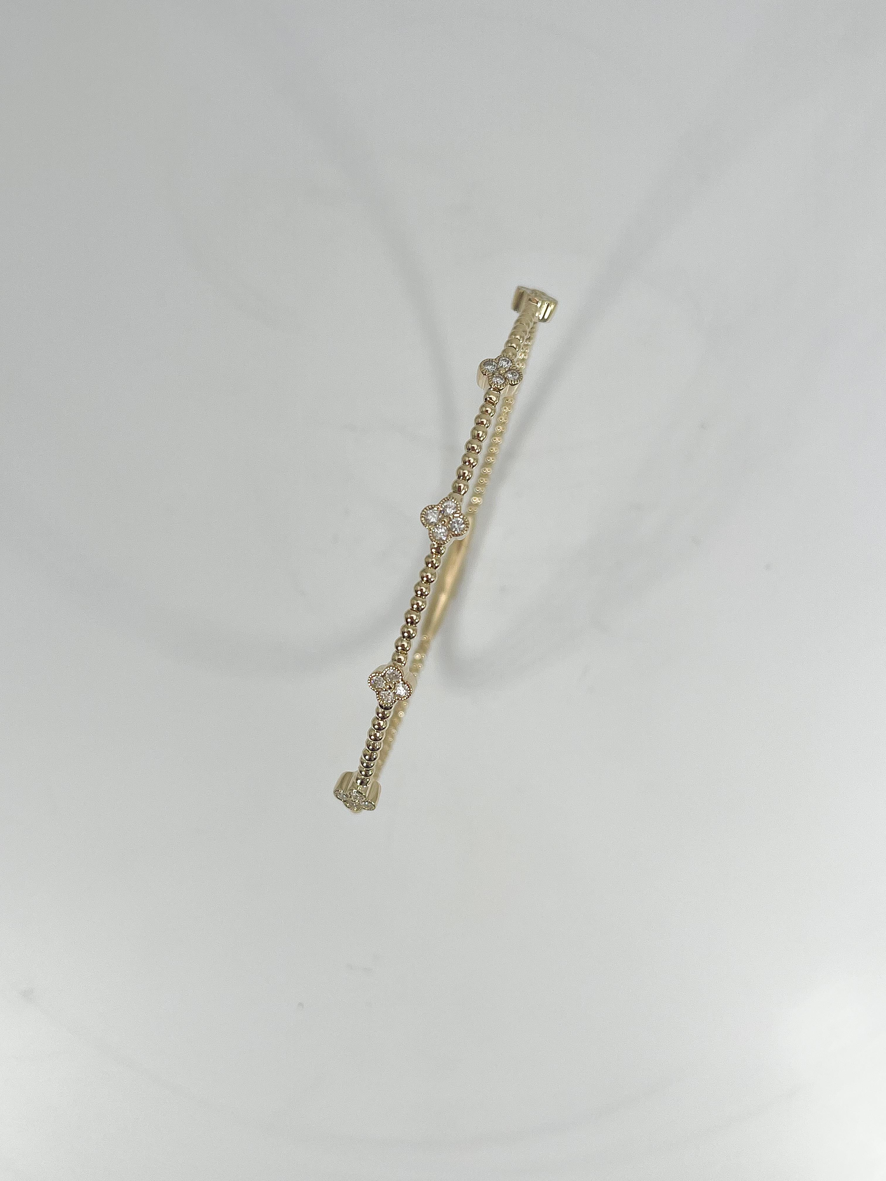 14k yellow gold .35 CTW diamond cluster flex bangle. The stones in this bracelet are all round, the width is 5 mm, the inside diameter is about 4 inches, and it has a total weight of 5.35 grams.
