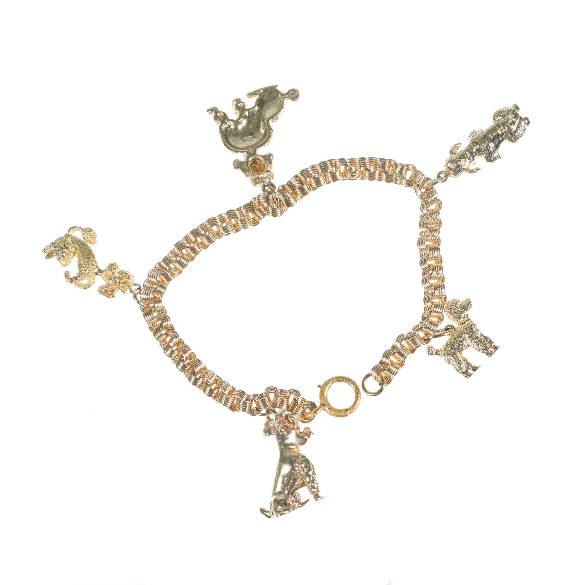 Vintage 1960's five poodle 14k yellow gold charm bracelet with four 3D and one 2D highly detailed different poodle charms. Triple spiral link bracelet with original textured spring ring. 7.5 inches.

14k yellow gold 
Stamped: 14k
33.4 grams
Length: