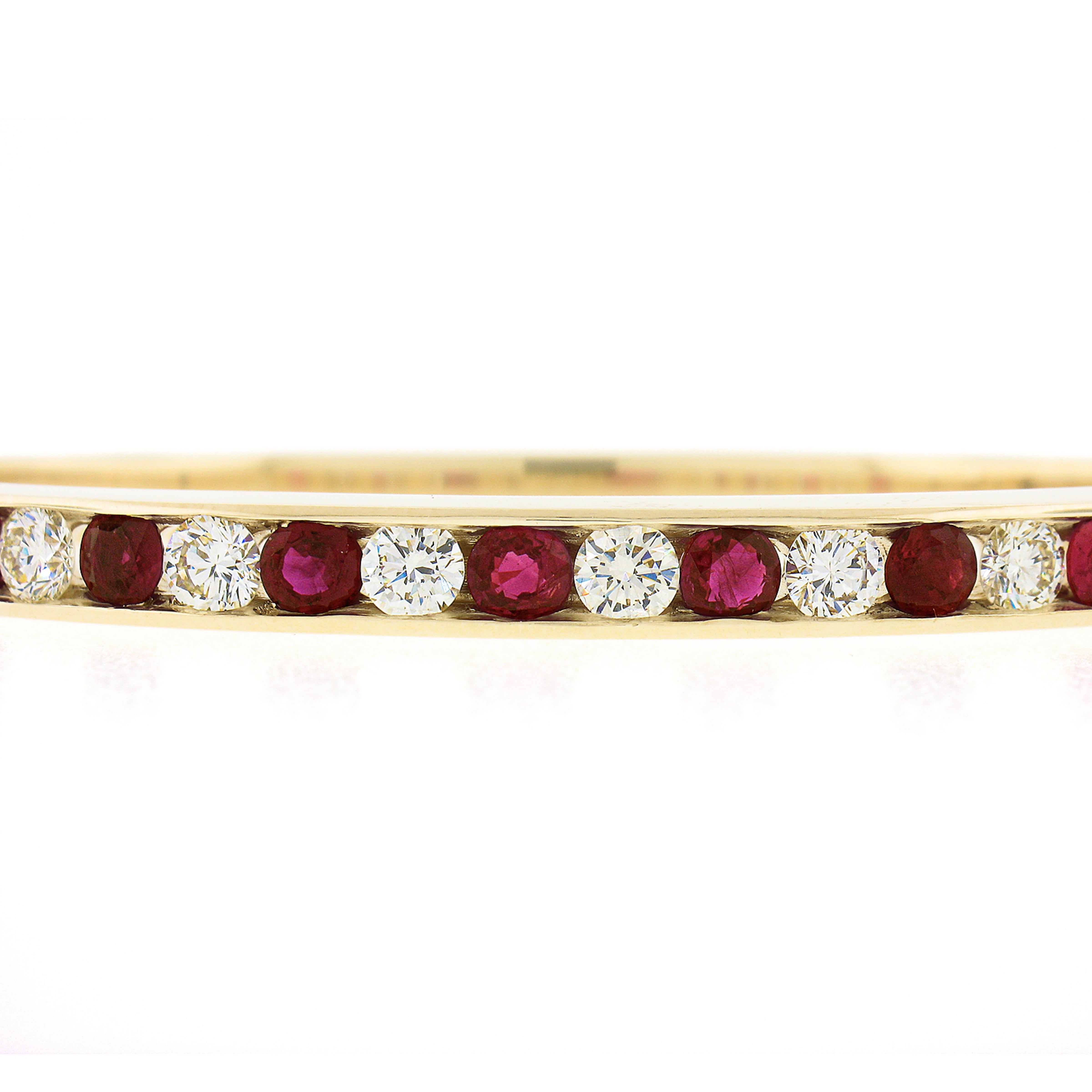 This gorgeous and very well made bangle bracelet was crafted from solid 14k yellow gold and features 7 stunning natural rubies and 7 fiery diamonds neatly channel set and gorgeously alternating across its top. These glamorous stones are each a nice
