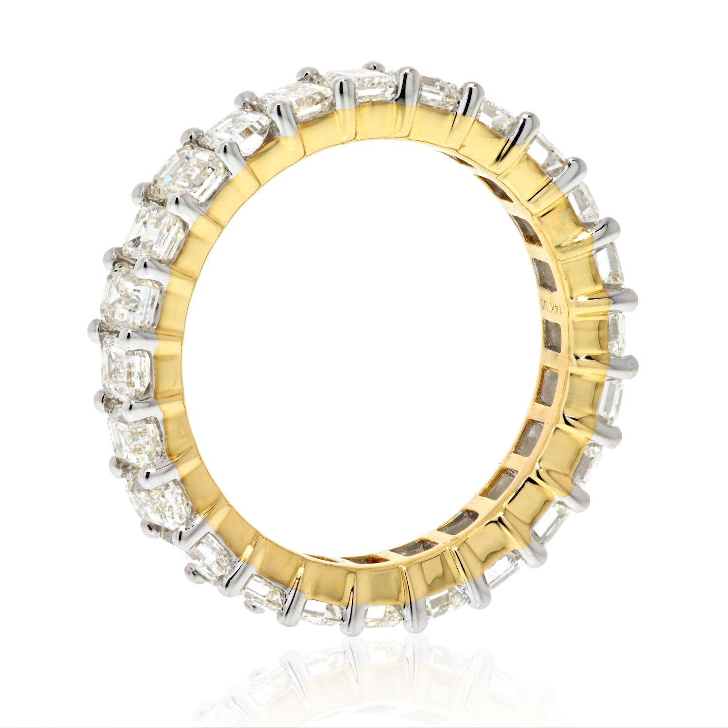 Perfect eternity band with emerald cut diamonds made in 14k yellow gold with white prongs. 
There are 24 diamnds totaling in 4.25cts. Shared prong low set mounting.
G-H color, VS-SI clarity. 
Size 7. 