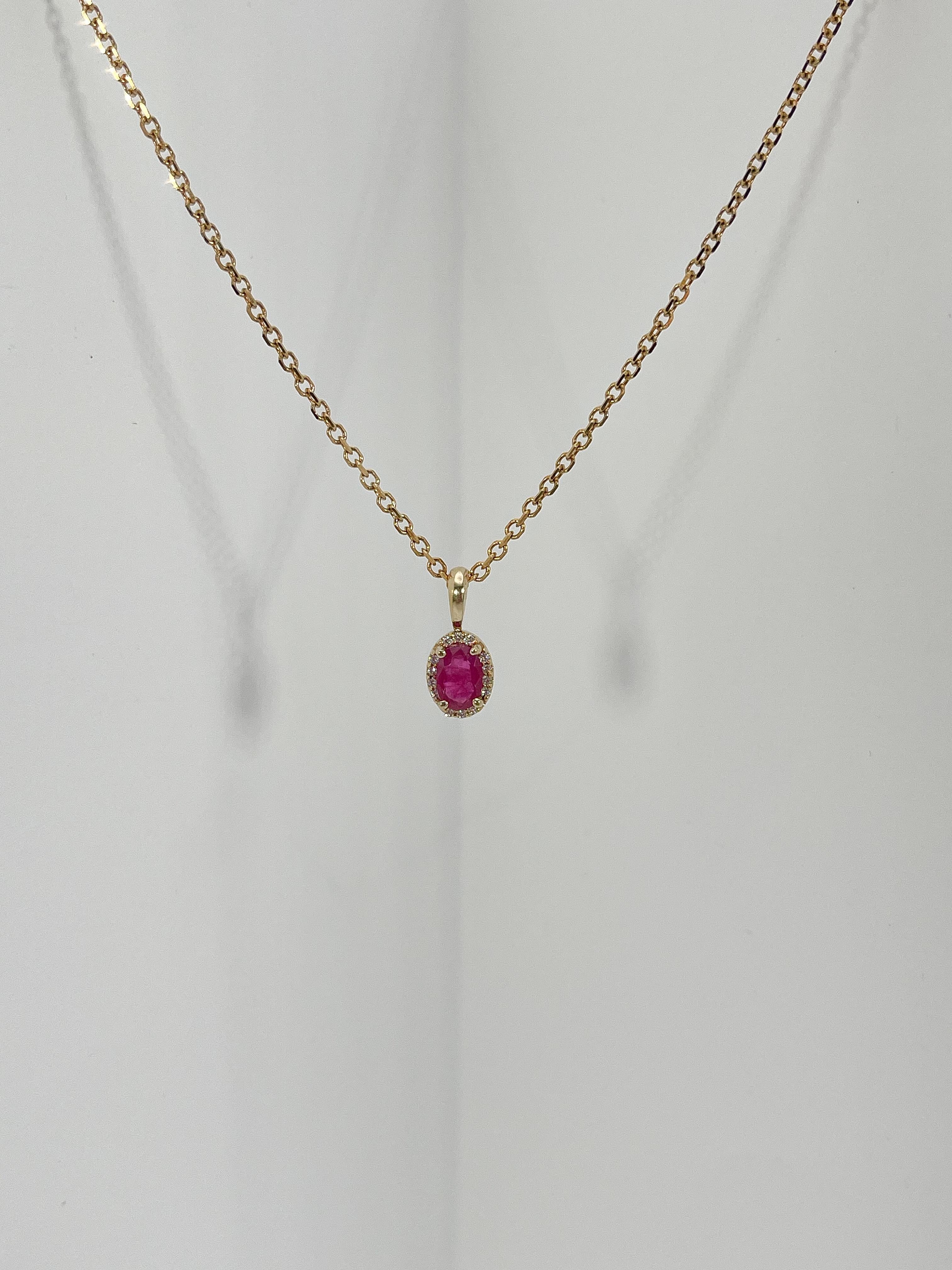 14k yellow gold .50 CTW ruby and diamond halo pendant necklace. The diamonds are all round and the ruby is oval, pendant comes on a 16 inch diamond cut cable chain, has a lobster claw to open and close, and has a total weight of 3.4 grams.