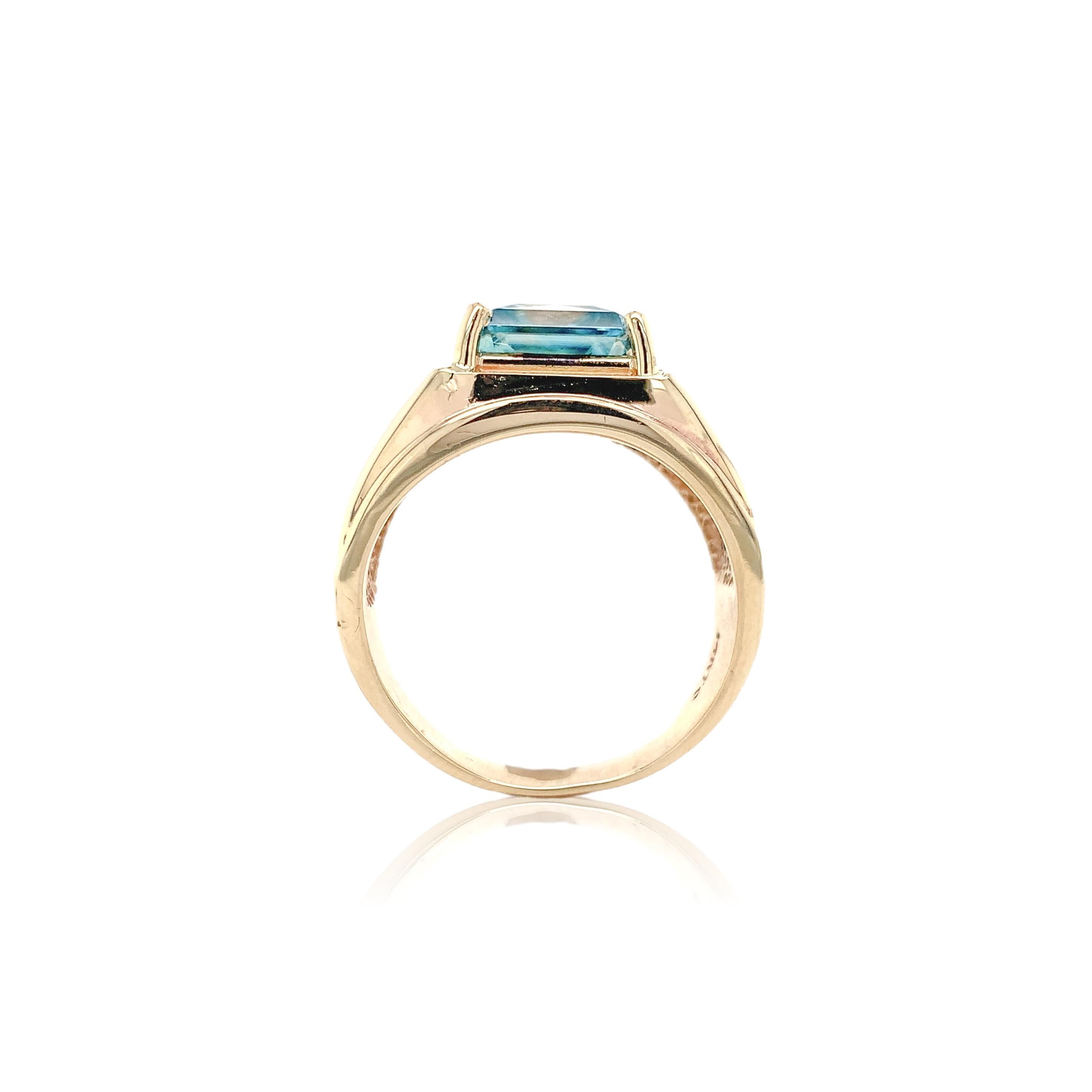 Bague pour homme en or jaune 14 carats ornée d'un zircon bleu naturel de taille brillant. Le zircon bleu a une couleur bleu verdâtre brillante. Il mesure environ 9 mm et pèse 5,27 carats. La bague convient à une taille de doigt 9, pèse 5.89dwt et