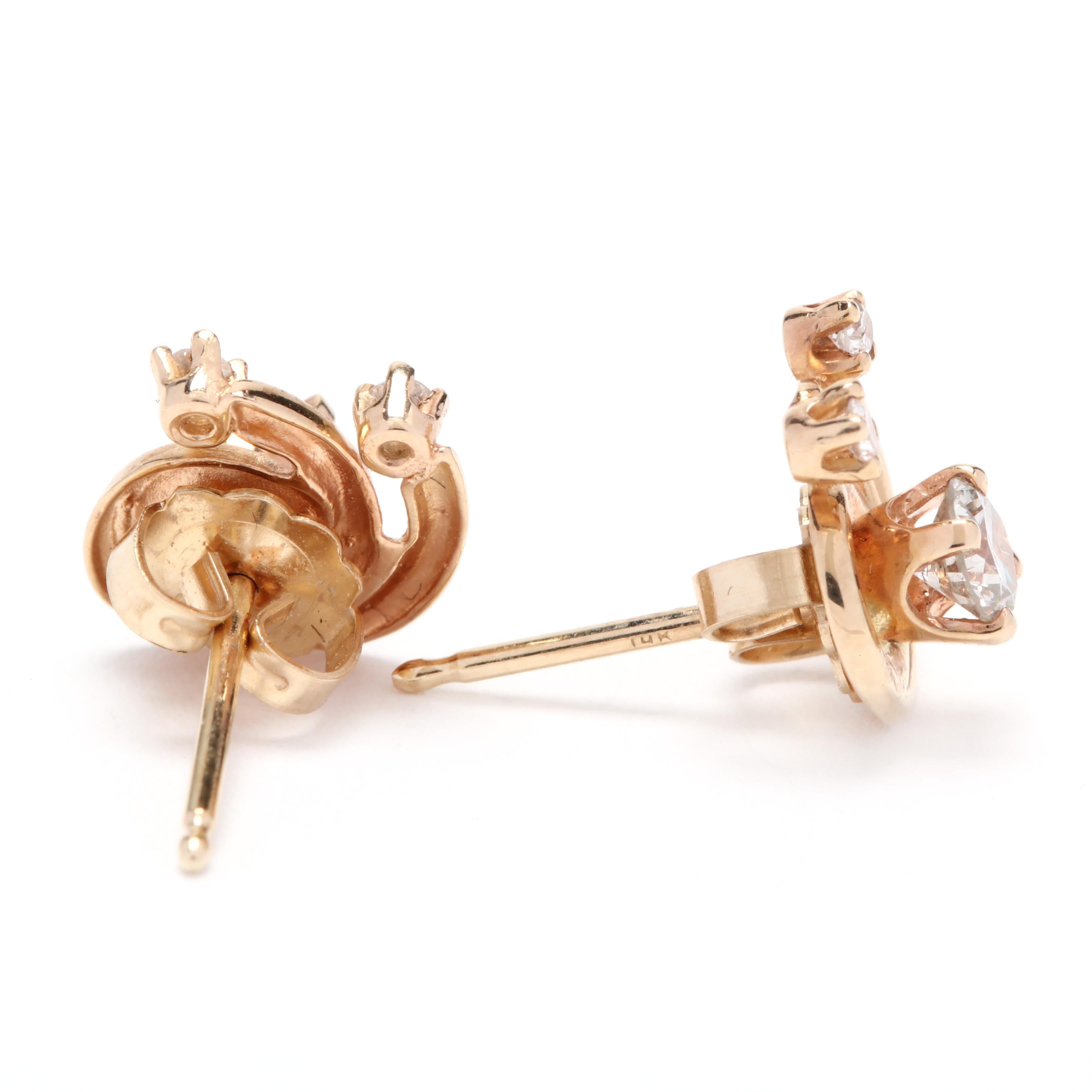 A pair of 14 karat yellow gold and diamond swirl stud earrings. These earrings feature a double row swirl motif centered on prong set full cut round diamonds and with prong set diamonds at each end of the swirl for an approximate total diamond