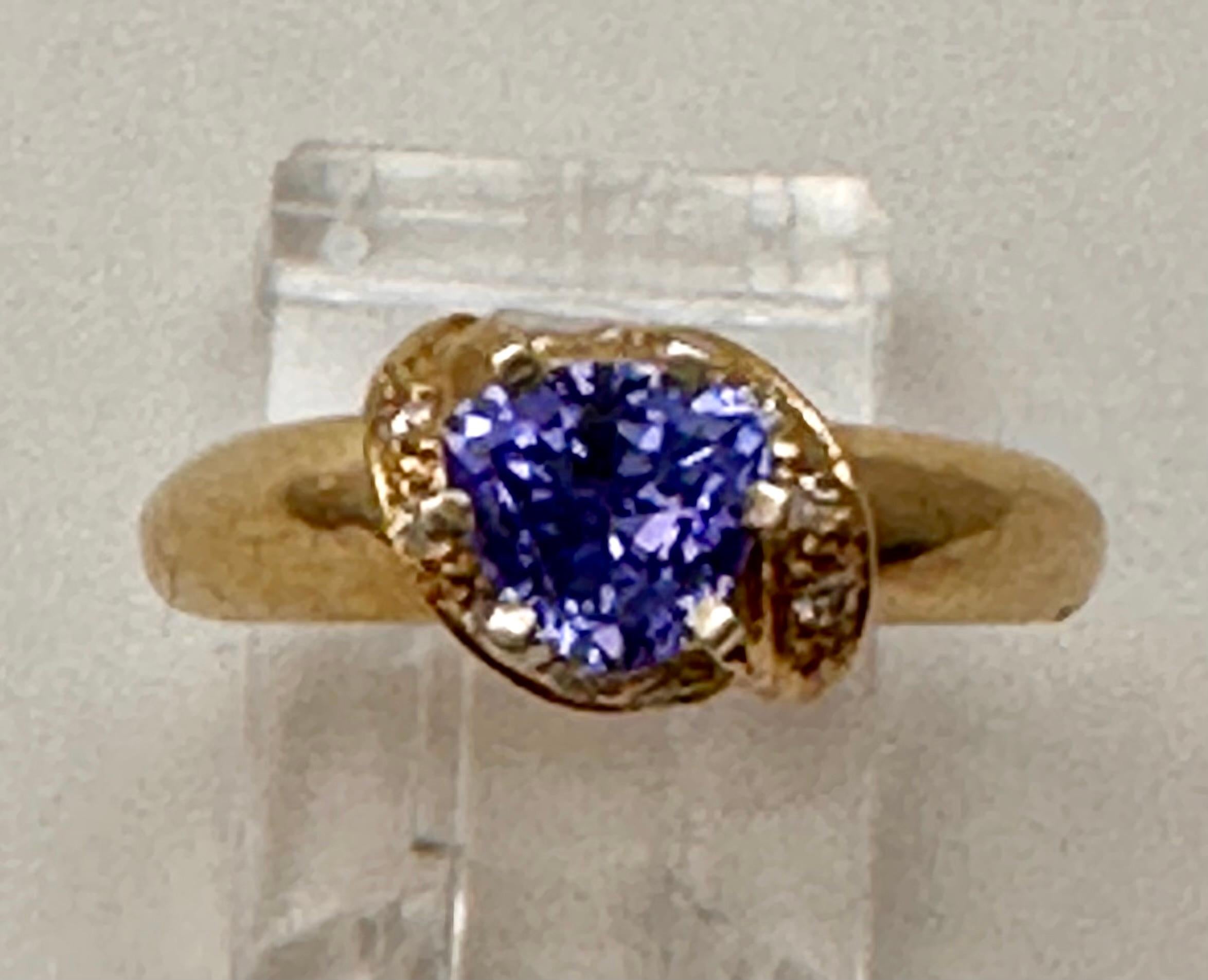 14k Yellow Gold 5.7mm Trillion Cut Tanzanite 10 round Diamonds 
Ring Size 6

Tanzanite 

Tanzanite changes colors when it is viewed from different directions. This shifting of colors has been said to facilitate raising consciousness. It aids in