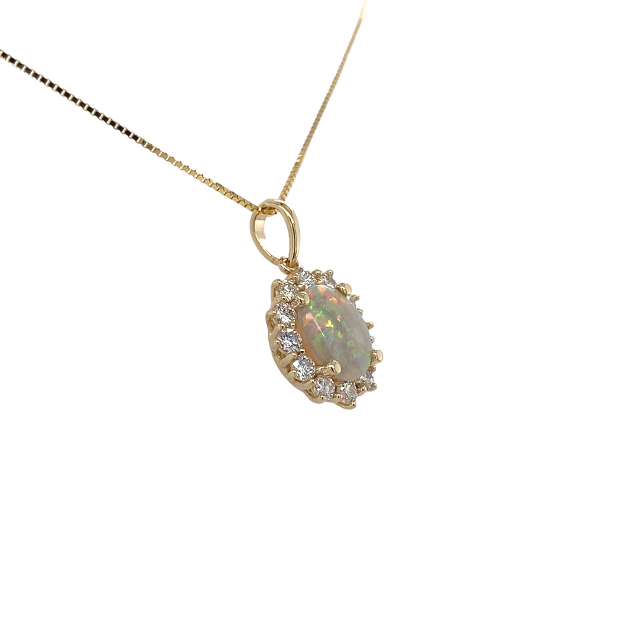 Pendentif en or jaune 14K de 0,59ct en opale australienne avec diamants. L'opale ovale en cabochon présente un jeu de couleurs vibrant avec toutes les couleurs, y compris beaucoup de rouge.  L'opale naturelle extraite de la terre mesure environ 8,4