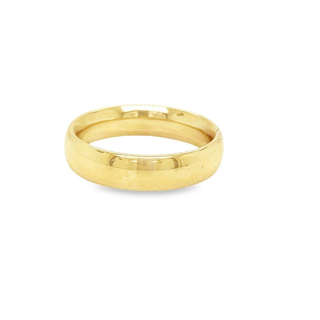 This beautiful wedding ring is made of 14k yellow gold and will create cherished memories that last a lifetime. It has a timeless design with a half-round shape, 5mm width, and a slightly curved surface, all crafted with exceptional skill. The