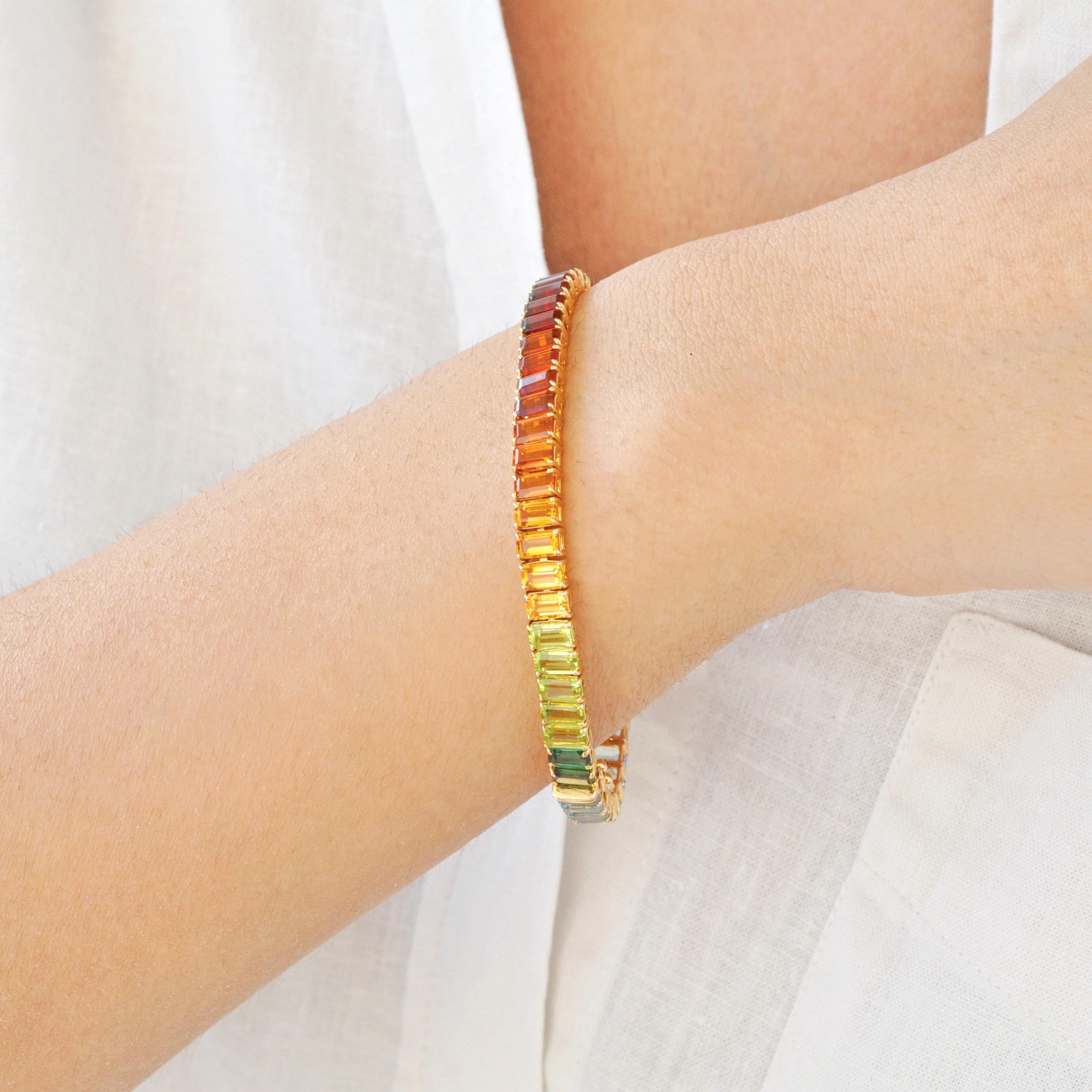 Dieses atemberaubende Tennisarmband aus 14 Karat Gelbgold ist ein kühner und doch raffinierter Ausdruck von Farbe und Handwerkskunst. Das Armband mit seiner schlanken, modernen Silhouette besteht aus einer Reihe von natürlichen Edelsteinen im