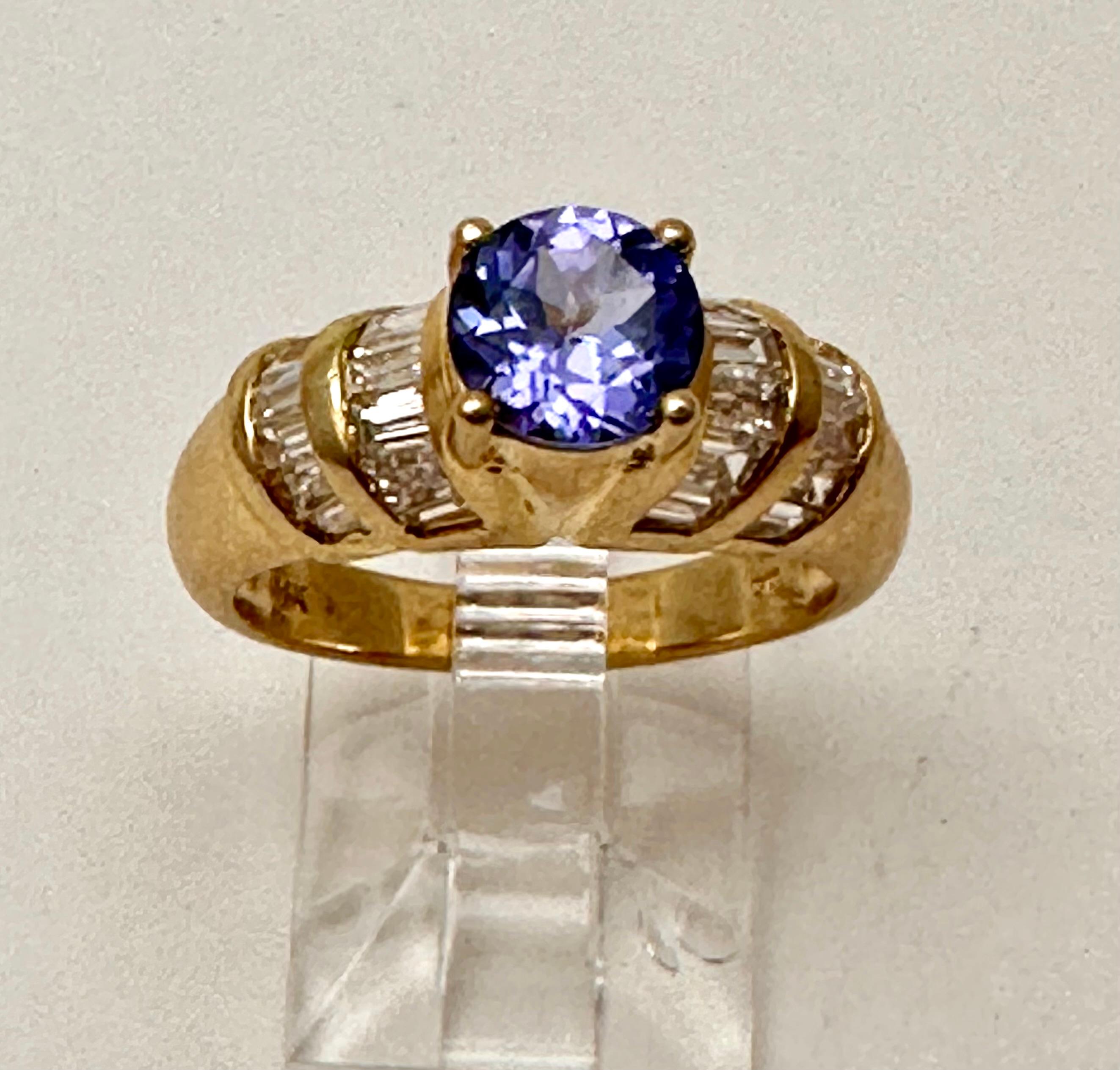 Anillo de oro amarillo de 14k con diamante tanzanita redondo de 6,5 mm talla 6,5 
Dos Filas de Baguettes a cada lado...precioso anillo 

Tanzanita 

La tanzanita cambia de color cuando se mira desde distintas direcciones. Se dice que este cambio de