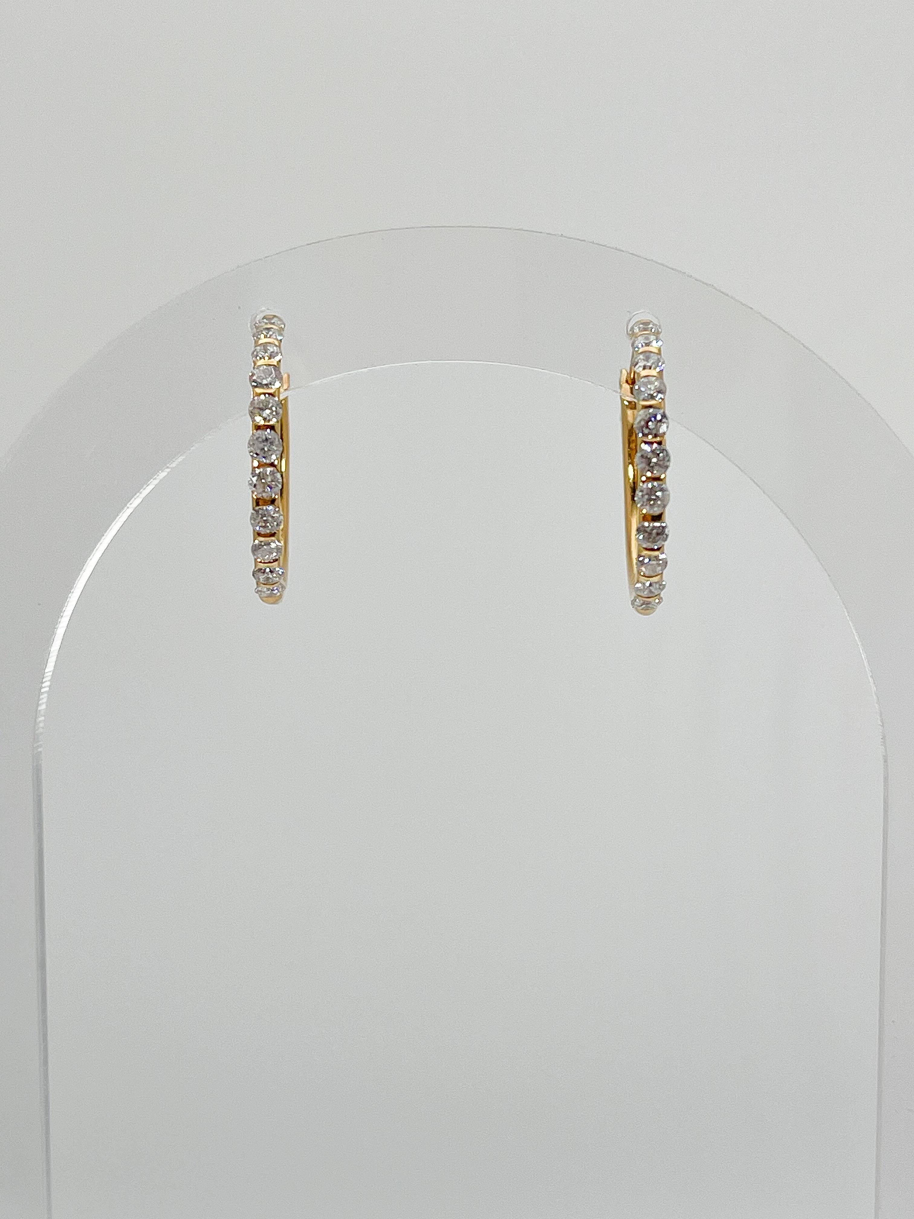 14k yellow gold .75 CTW Diamond Hoop Earrings. These earrings have 11 round diamonds on each hoop, they have a diameter of 20.5 mm, and weigh a total of 3.2 grams. 