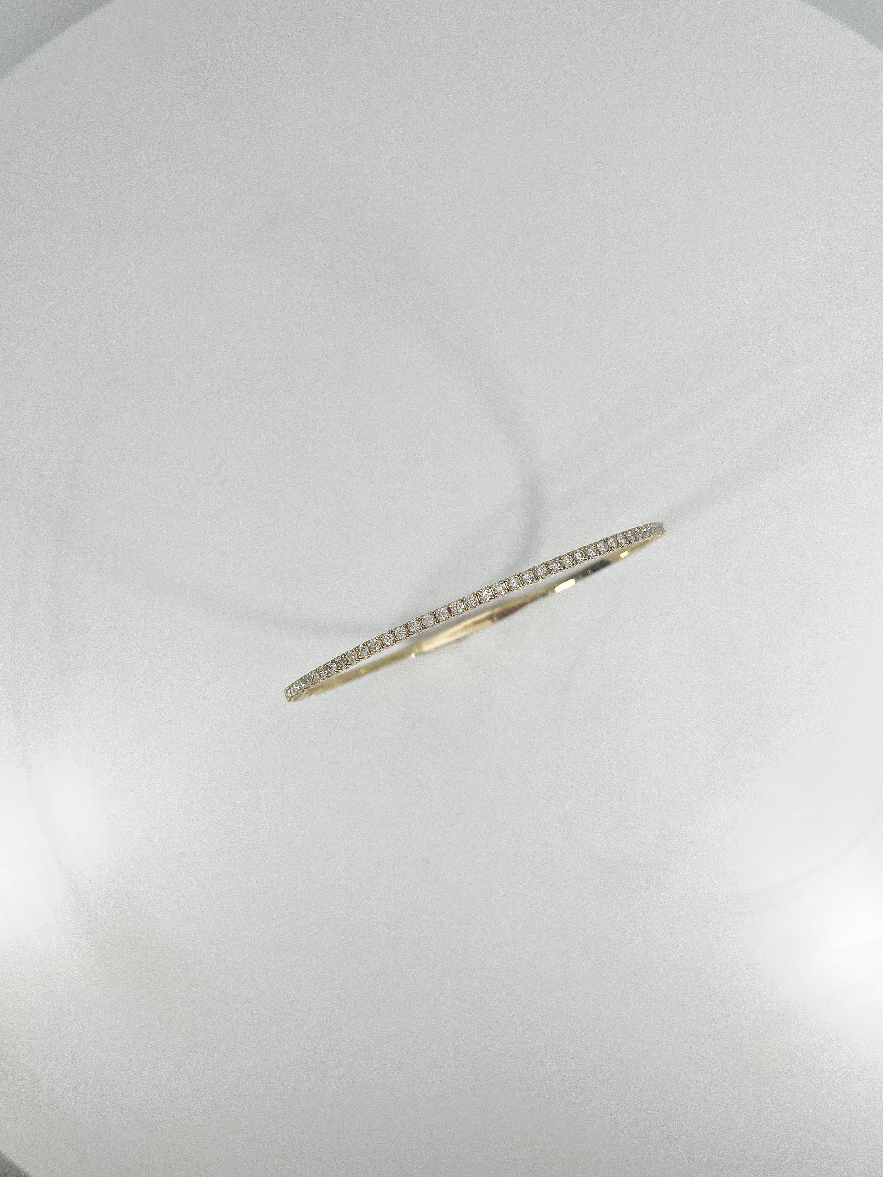 14k yellow gold .85 CTW Diamond Flex Bangle. The diamonds in this bracelet are all round, the width measures 2 mm, the inside diameter is about 4 inches, and it has a weight of 5.94 grams.