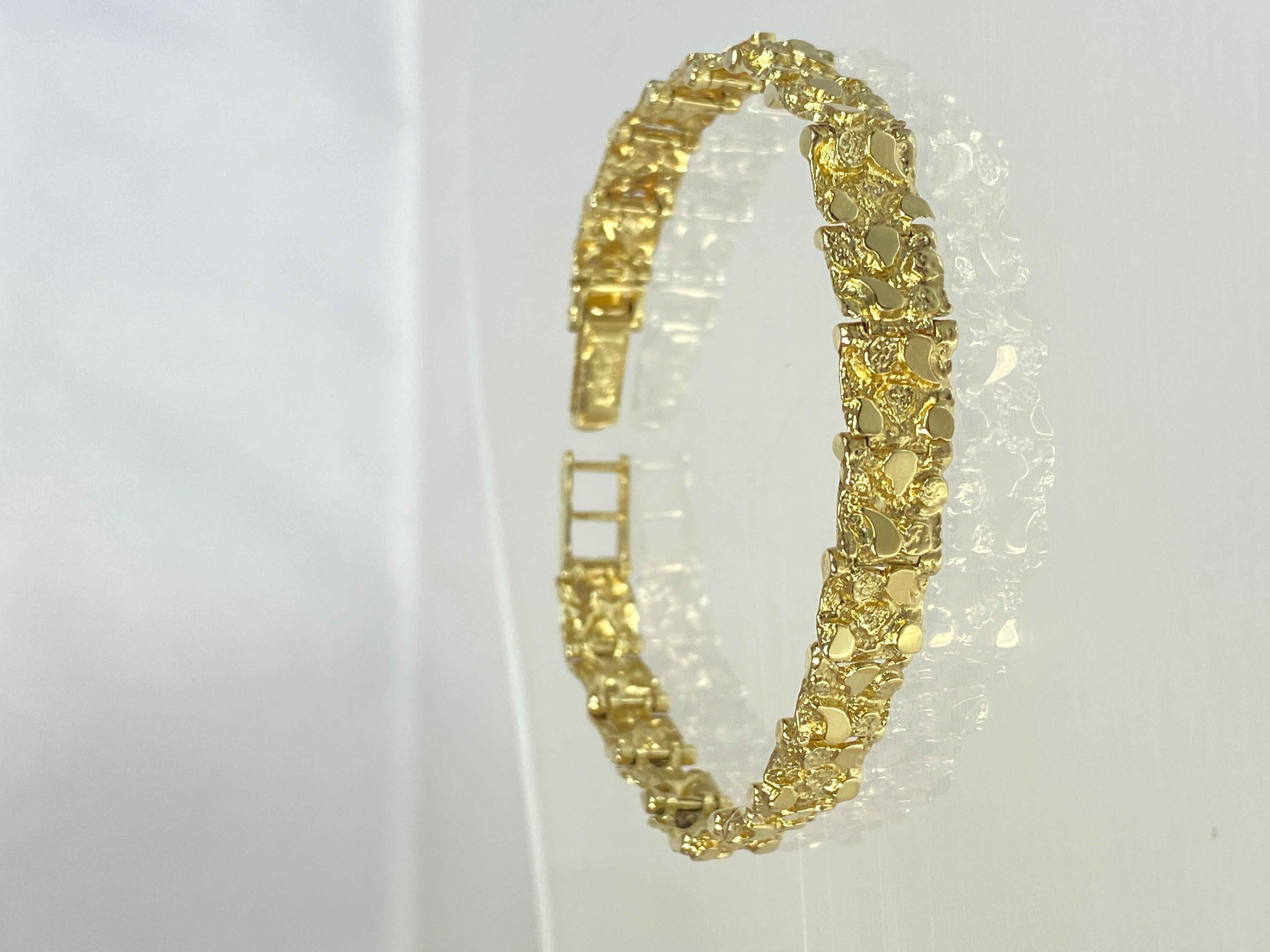 This solid 14k yellow gold nugget style bracelet for women exudes a timeless elegance and rugged charm. Crafted with meticulous attention to detail, this bracelet features nugget-shaped gold, carefully textured to mimic the natural irregularities of