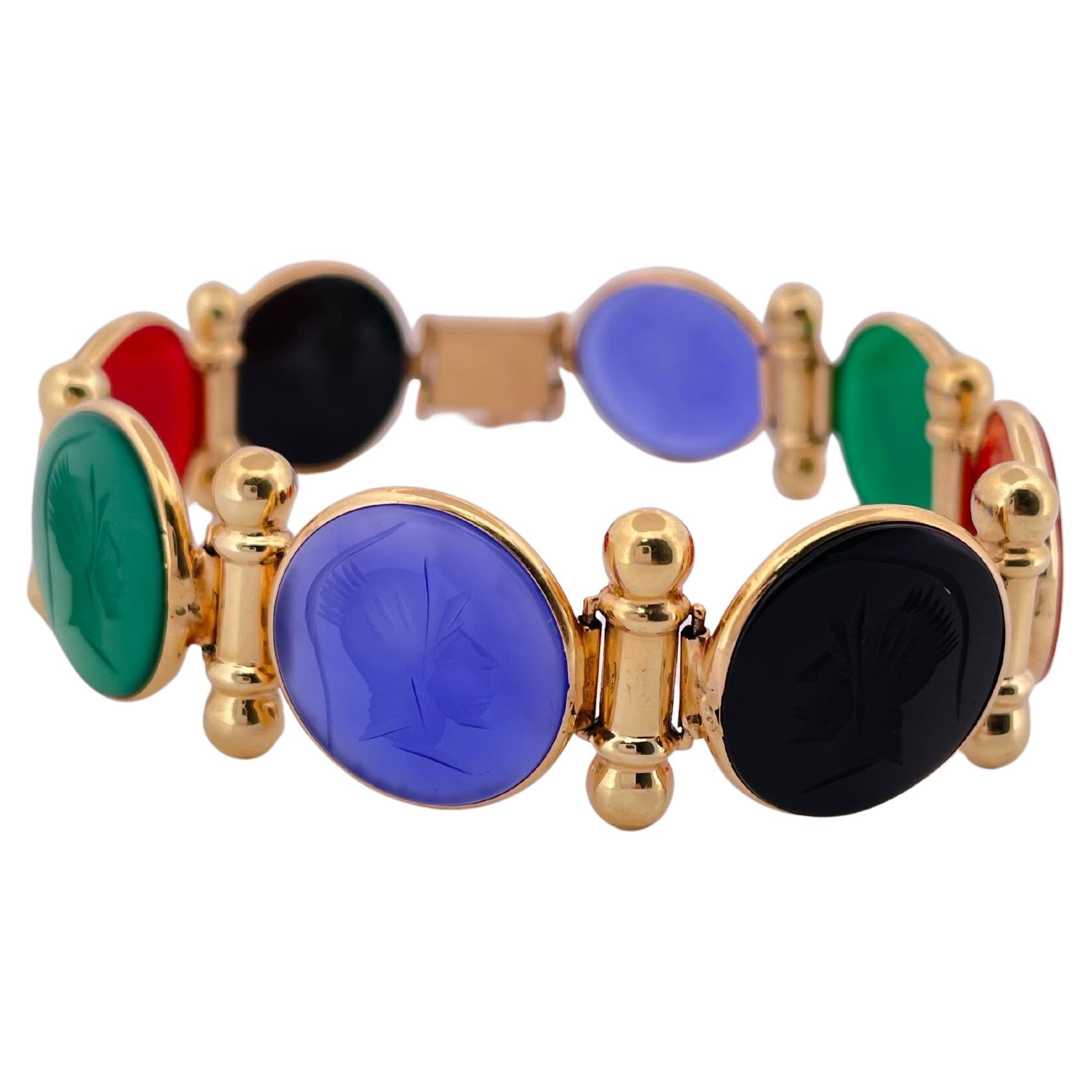 Ce remarquable bracelet en or jaune 14 carats présente une vibrante collection de camées sculptés en onyx et en agate, chacun représentant un profil classique finement détaillé. Présentant un éventail harmonieux de couleurs audacieuses - onyx noir