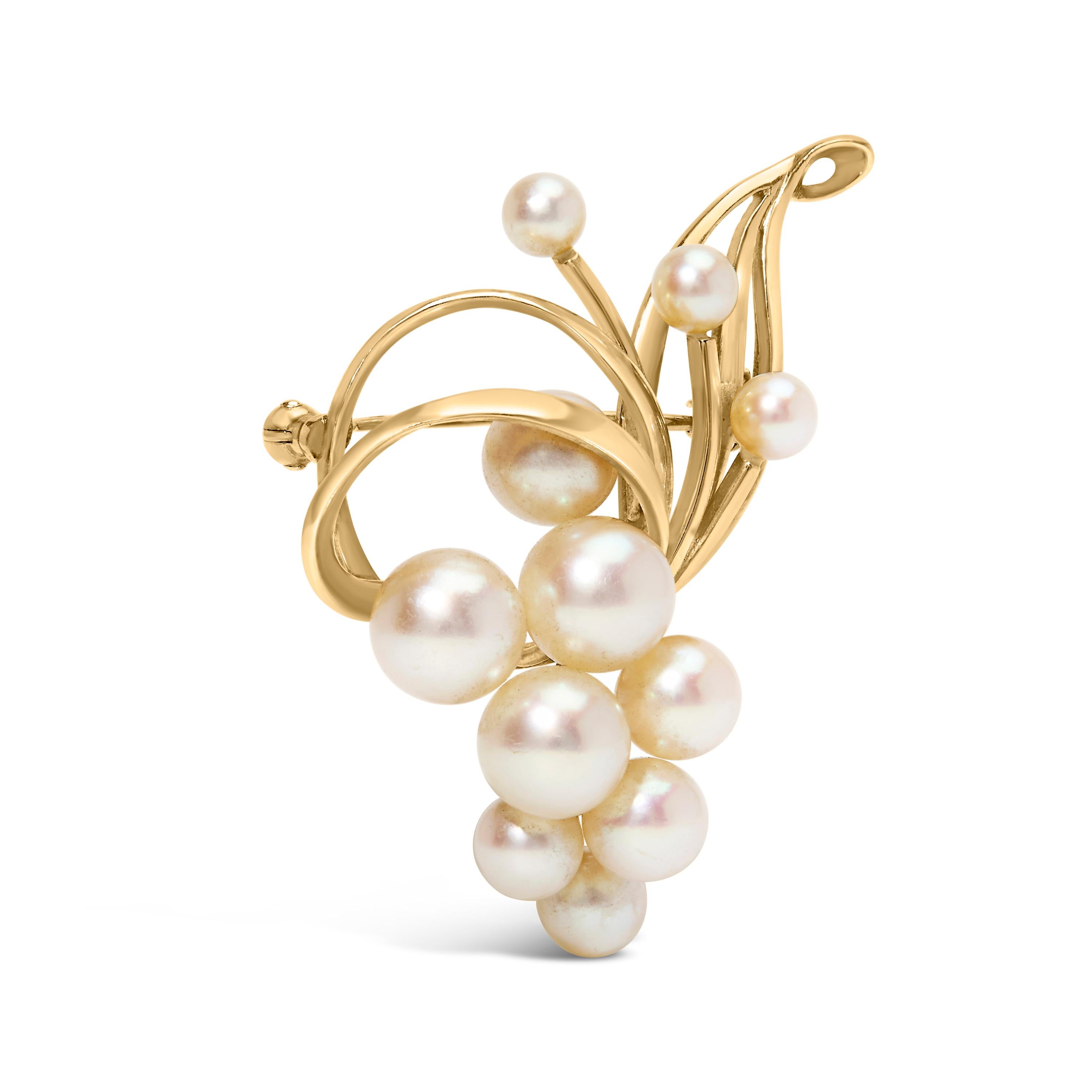 Drape yourself in the opulence of the Orient with this exquisite brooch, where eleven Japanese Akoya pearls, ranging from 3 mm to 5 mm, cluster like dewdrops within an embrace of luxuriously swirling 14K yellow gold. Each pearl, cultivated with