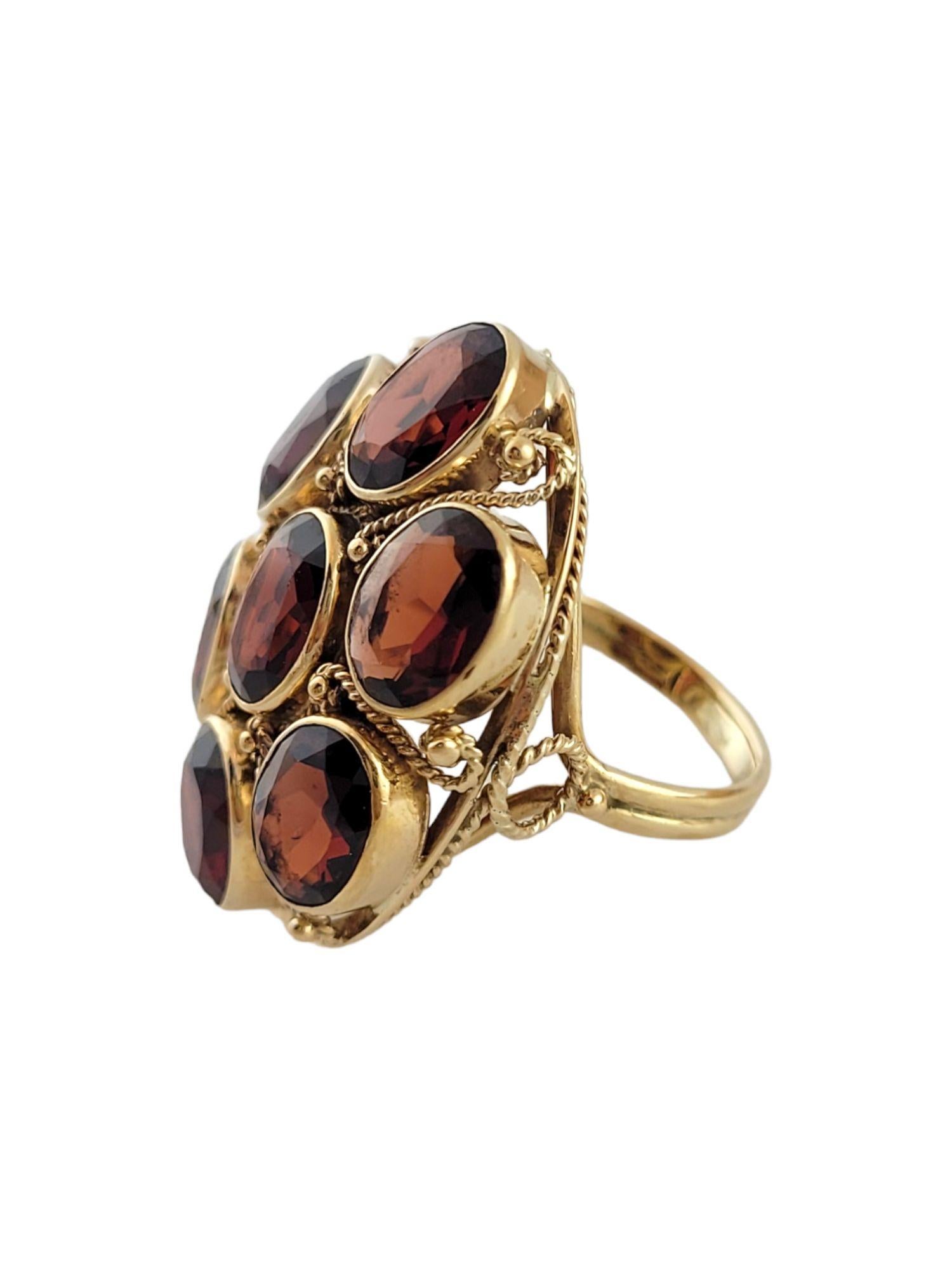 Gorgeous 14K gold cocktail ring with 9 beautiful almandine garnets!

9.80 cts.  in garnets. stones are eye clean with medium light brownish red color and good cut

Ring size: 6

Shank: 2.6mm

Front: 30.1mm X 23.1mm X 8.7mm

Weight: 9.12 g/ 5.9