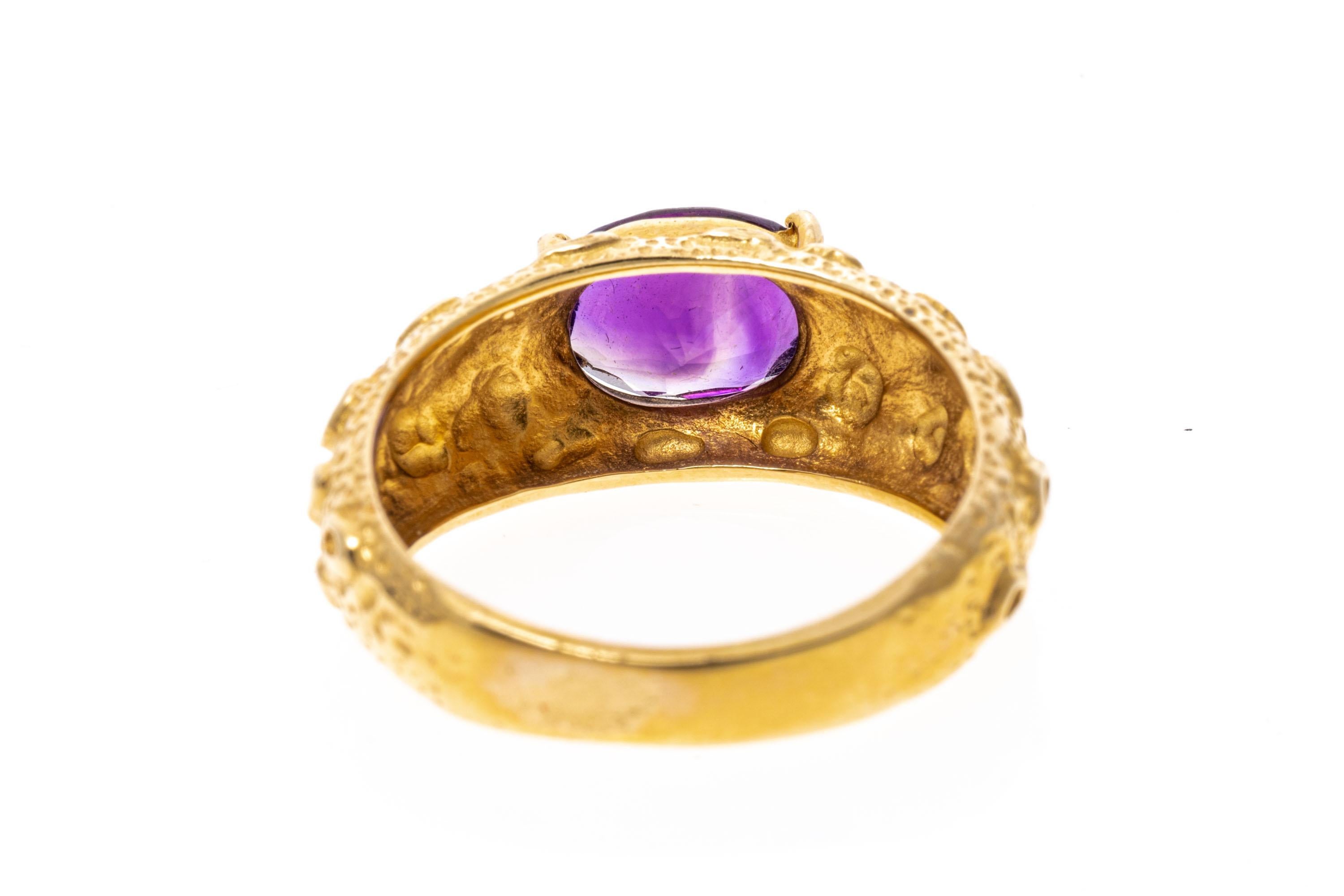 14k yellow gold ring. This striking ring has a horizontal, oval faceted, medium to dark purple color amethyst, approximately 1.42 CTS, prong set into a unique, moon crater style finished wide mounting.
Marks: 14k
Dimensions: 5/16