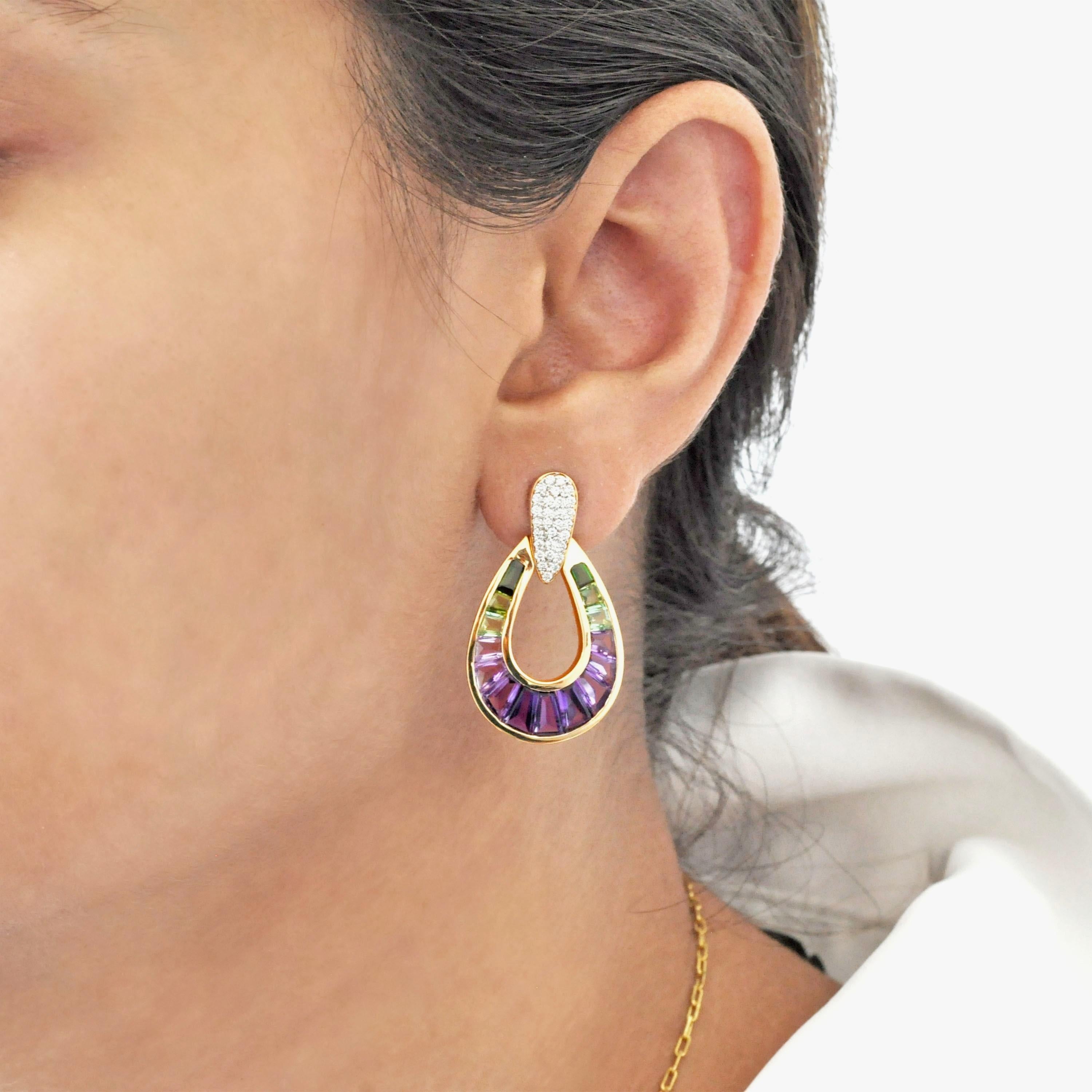Préparez-vous à être enchantés par nos boucles d'oreilles baguette en or jaune 14 carats, avec améthyste, tourmaline verte et diamant en forme de goutte d'eau.
Méticuleusement fabriquée, cette paire étonnante allie harmonieusement l'élégance