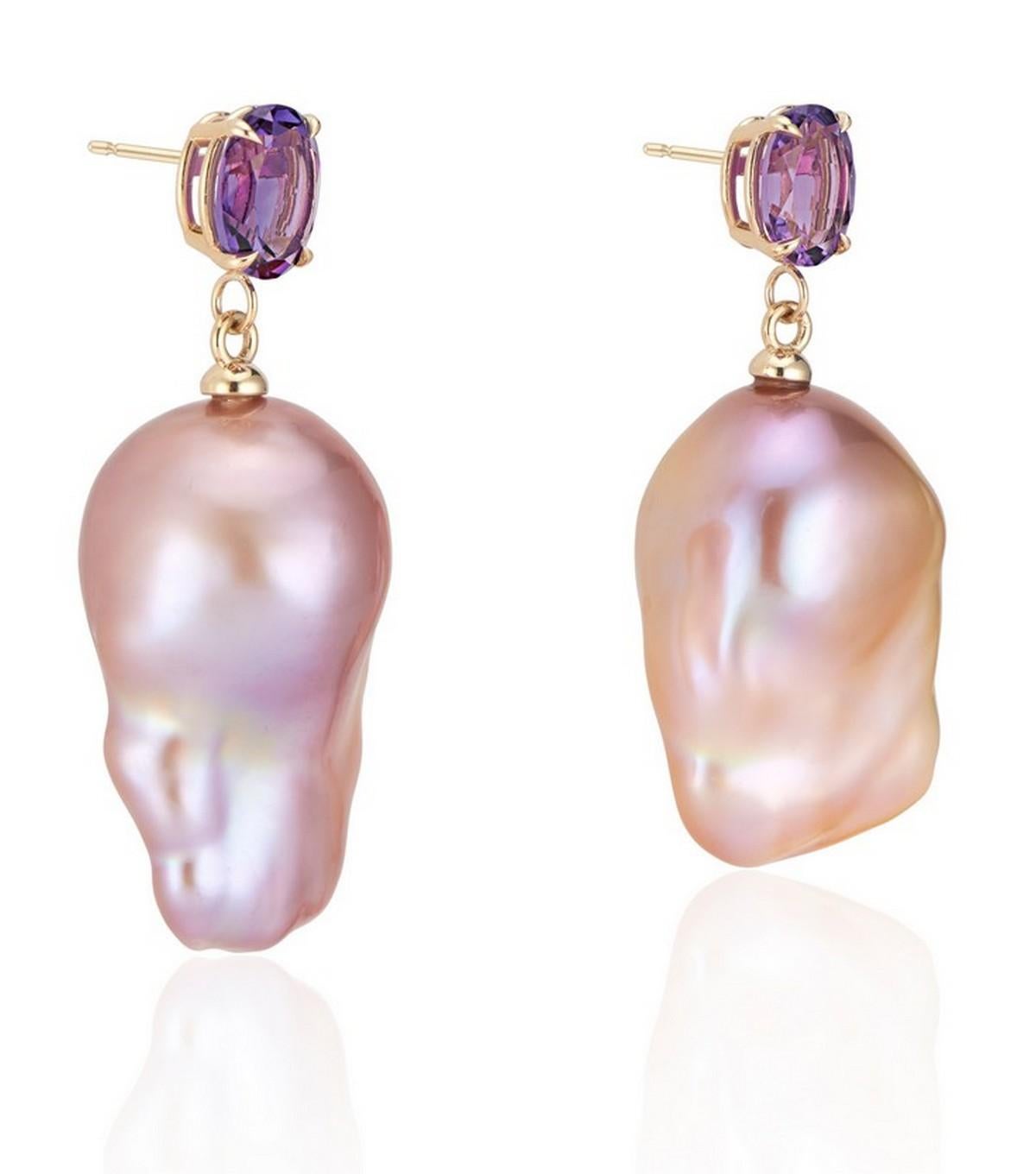 Our newest baroque pearl earring collection features this exquisite pair: a strikingly set dark royal purple amethyst on a polished 14K yellow gold basket setting, harmoniously paired with a pinkish-purple hued natural baroque pearl.

The deep