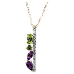 Penda con barra vertical de oro amarillo de 14K con amatista, peridoto y diamantes, y varias piedras preciosas