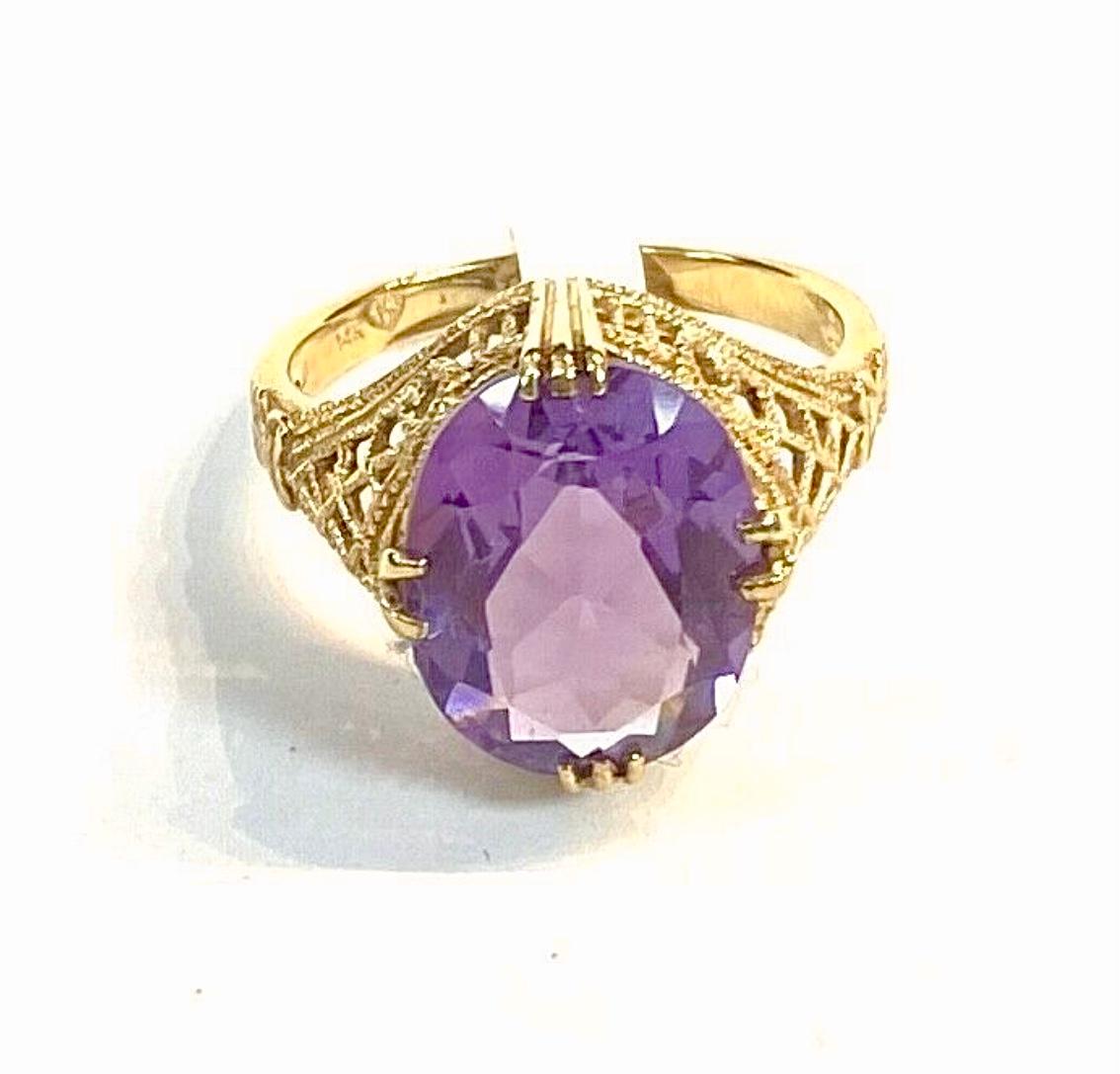 14k yellow gold oval Amethyst ring, 4.89 Grams TW. The dimensions of the oval amethyst are approximately 14 mm x 9.5 mm. Approximately 5.0 carats. Marked14k. Approximate size 7.5.