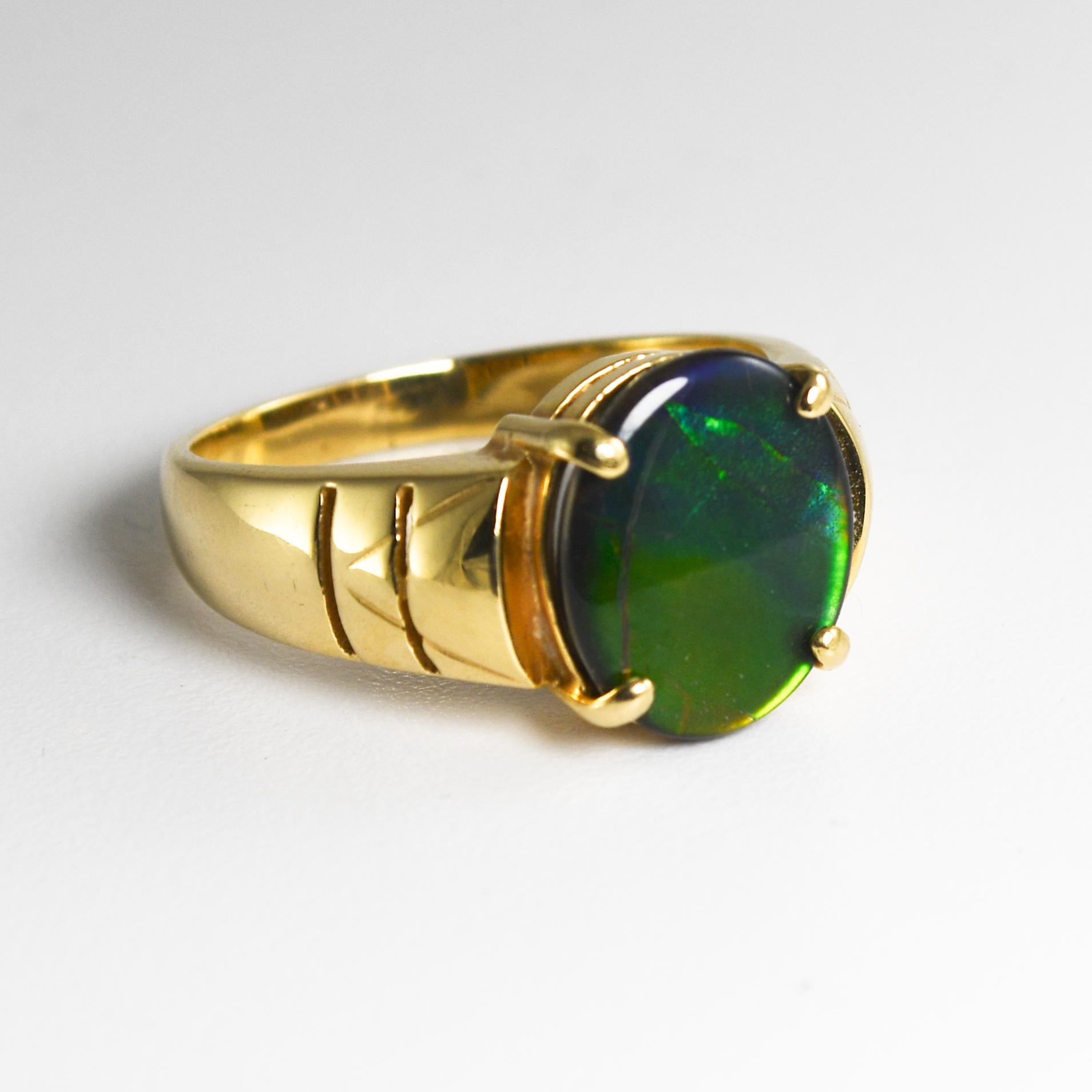 14k yellow gold and ammolite ring.
Stamped 14k and weighs 5.1 grams gross weight.
Ammolite has similar visual qualities as opal.
It's made from fossilized ammonite shells.
The stones' primary colors are orange and green with hints of blue.
It
