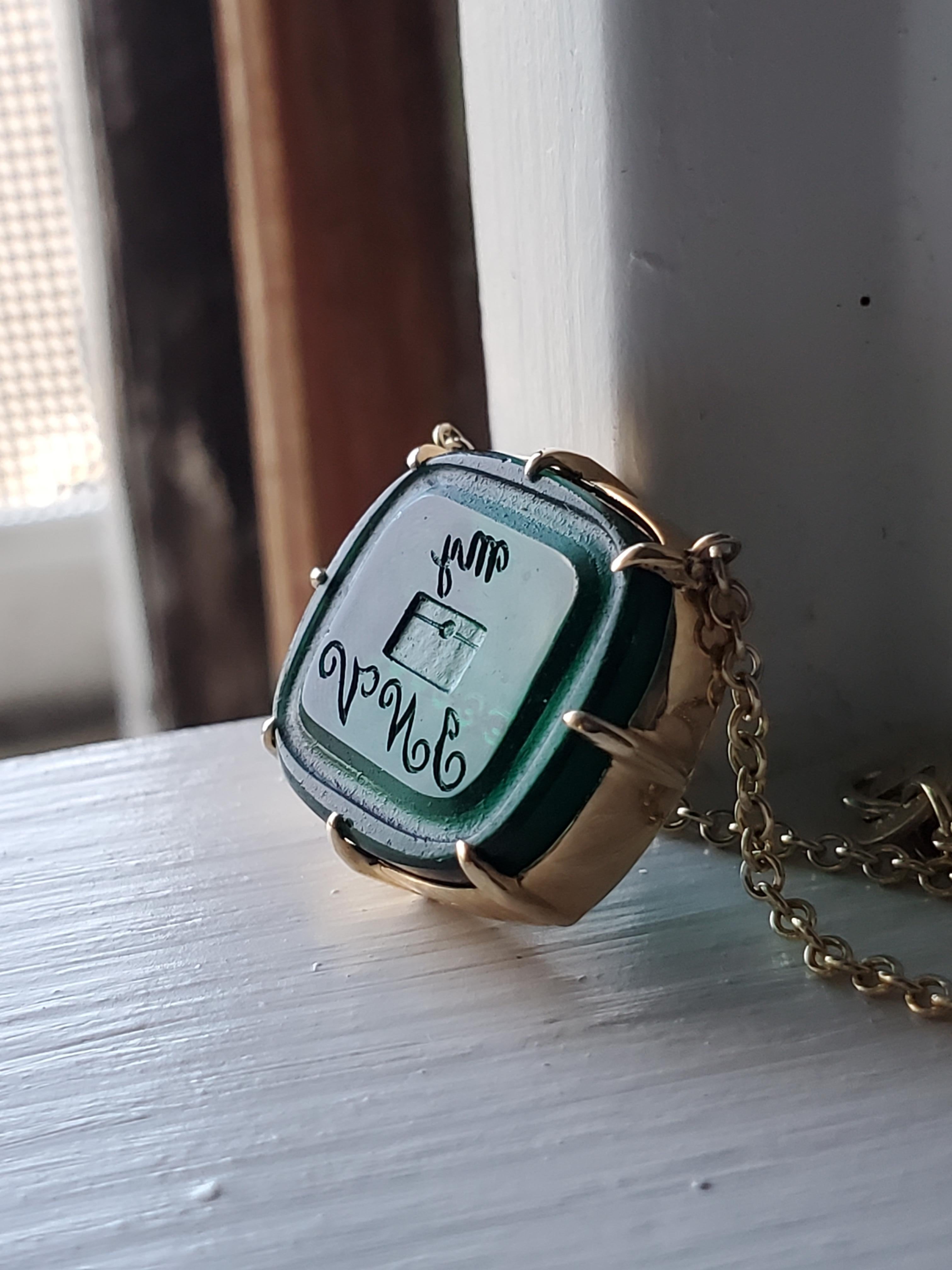 La nostra collana di sigilli in oro 14k e calcografia antica presenta uno splendido sigillo in vetro antico, unico nel suo genere, di un bellissimo colore verde acqua intenso, uno dei nostri preferiti. Questo pezzo è un Rebus, un intelligente puzzle