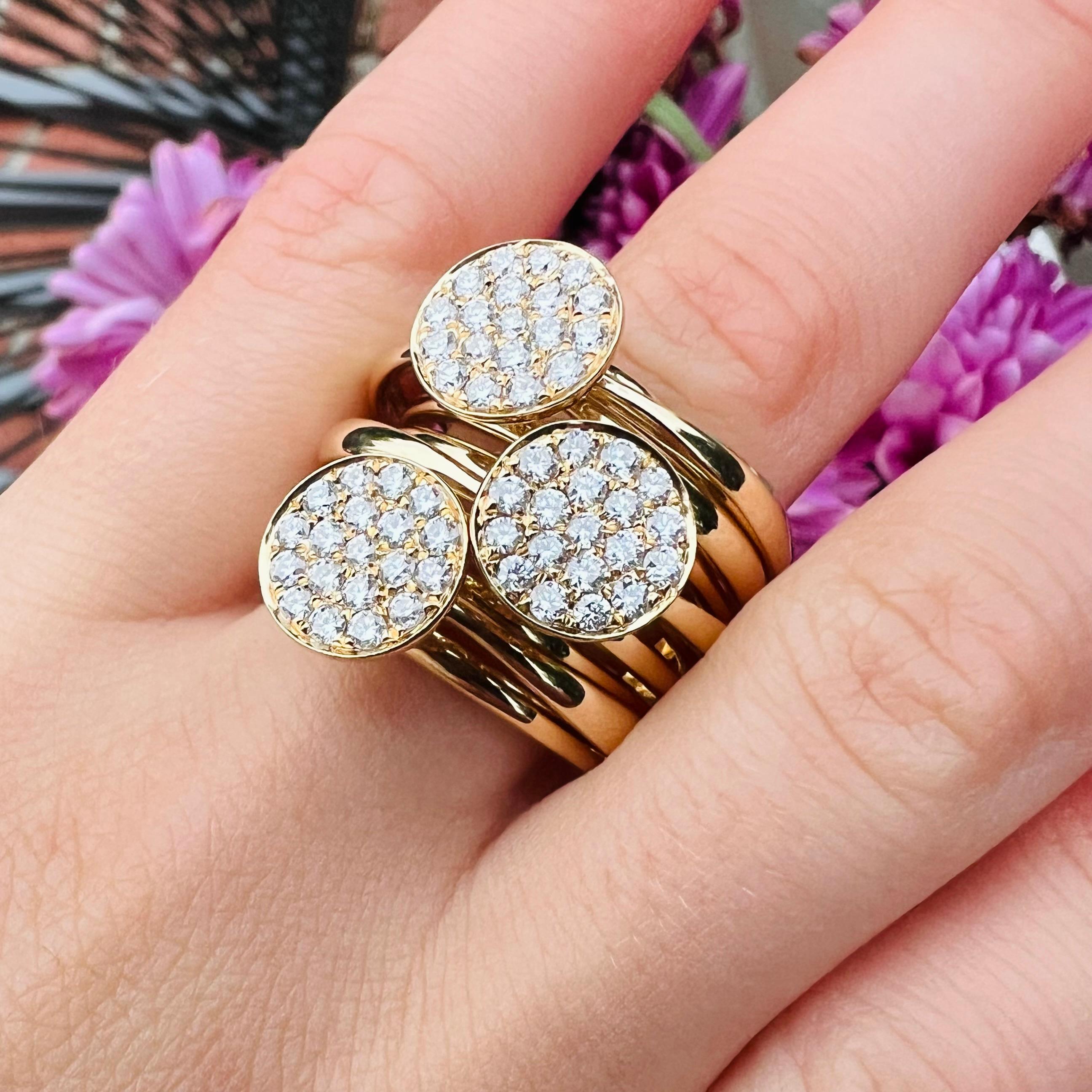 Stacking made easy! This fun and modern design is a play on stacking rings, with numerous, overlapped 14k gold bands highlighting three round disks, pave-set with 57 round brilliant-cut diamonds, weighing in total 1.16 carats, G-H/VS grading. The