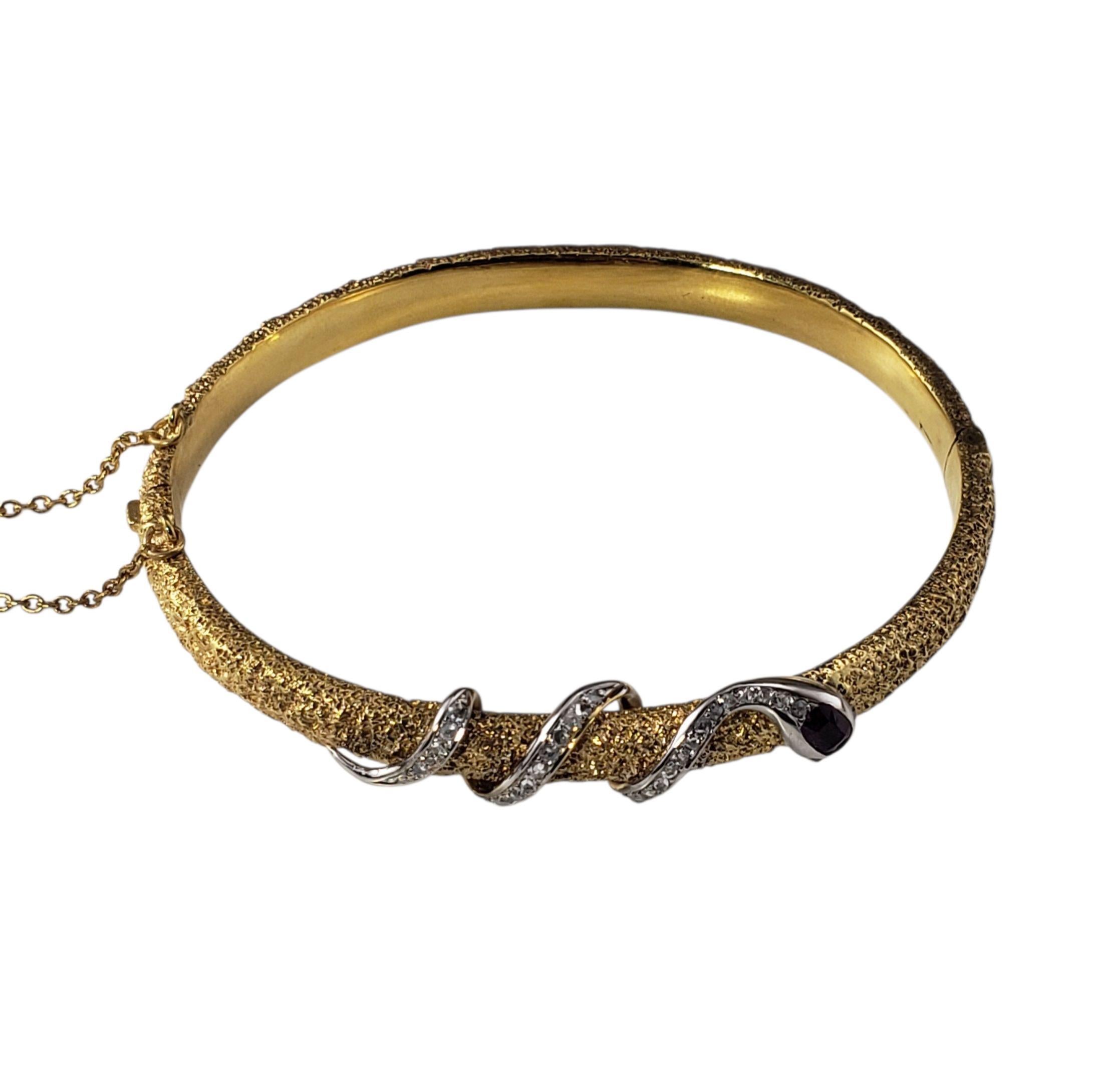 14K Yellow Gold and Diamond Textured Snake Bangle Bracelet-

This captivating bangle bracelet is crafted in 14K yellow gold with a richly textured finish, formed in an elegant serpent motif that coils around the wrist. The snake's head is set with a