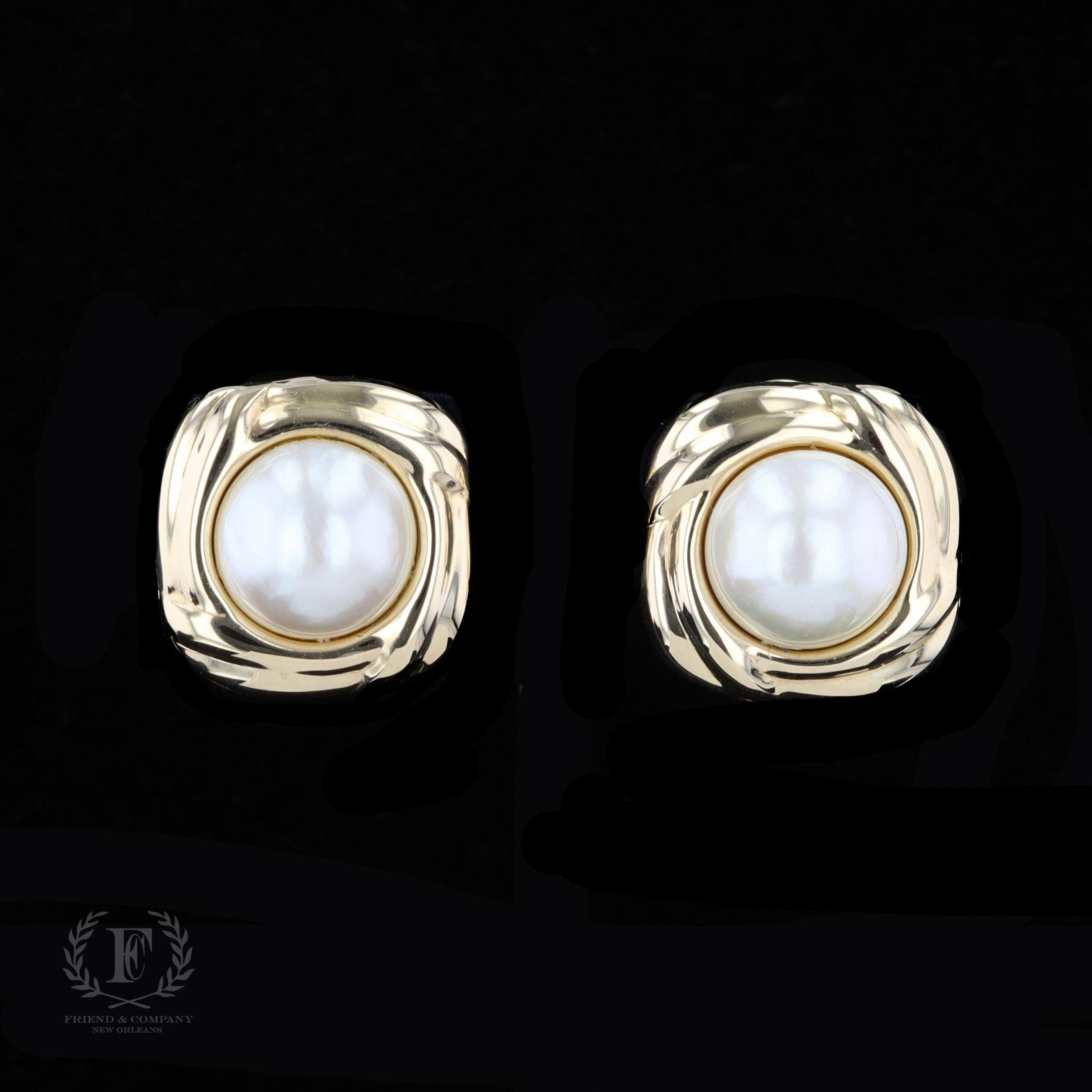 An elegant and timeless pair of earrings to add to your collection. This beautiful pair of 14 karat yellow gold earrings feature two round Mabe pearls measuring 13-14 millimeters each. The earrings are finished with clip-on backs.