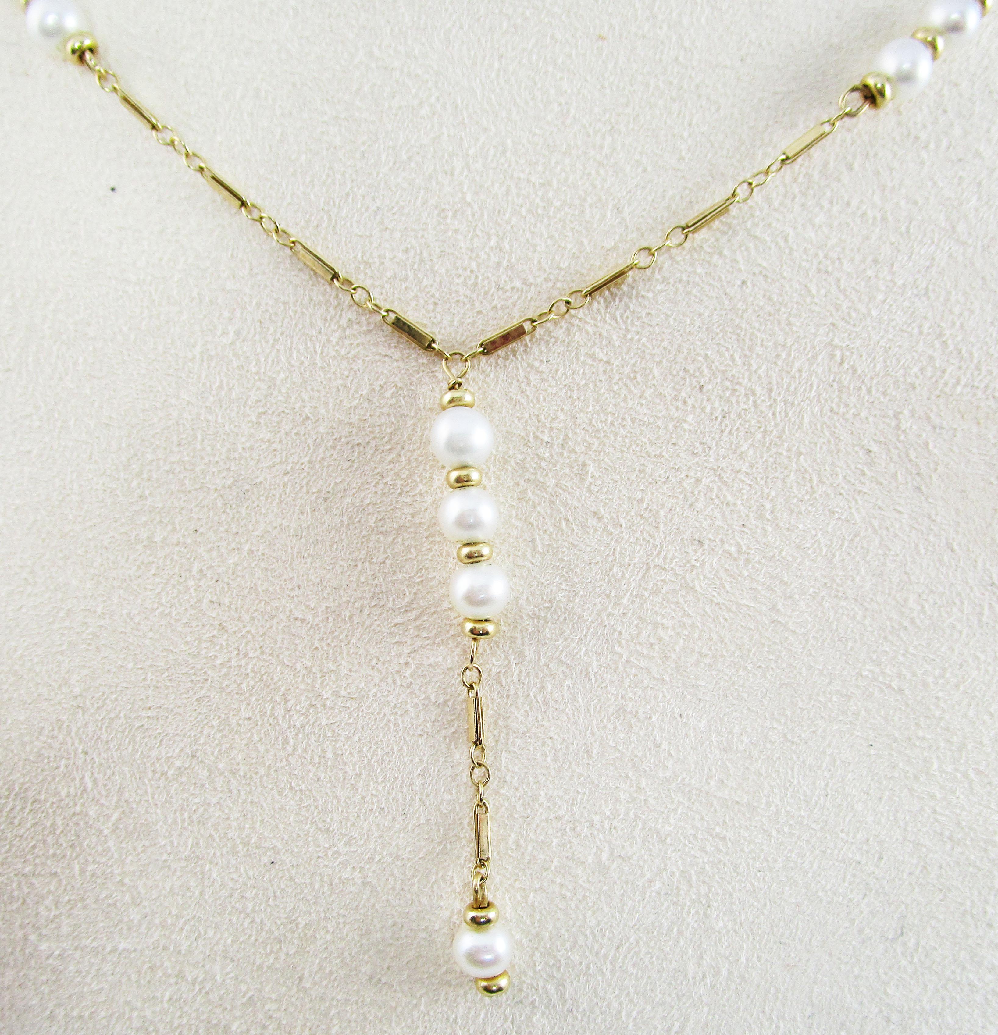 This is a magnificent lariat style necklace in 14k yellow gold featuring a gorgeous array of stunning white pearls. The silvery overtone and incredible luster of the pearls is the perfect complement for the warmth of the yellow gold. The pearls