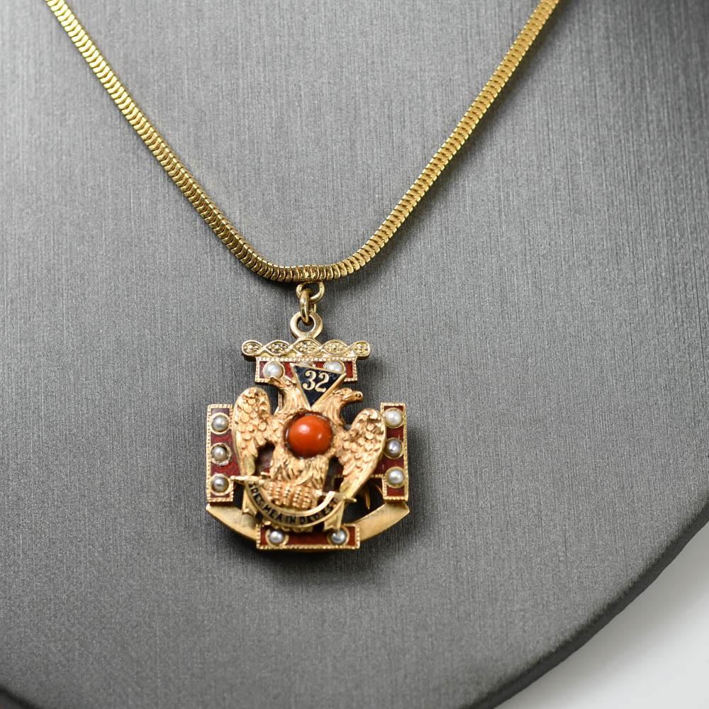 Scottish Rite Freemason pendant necklace in 14k yellow gold.
Stamped 14k and weighs 37 grams.
The pendant has small seed pearls and a red coral bead in the center.
The pendant measures 1 1/4 inches by 1 inch. 
 The necklace measures 2mm wide 
The