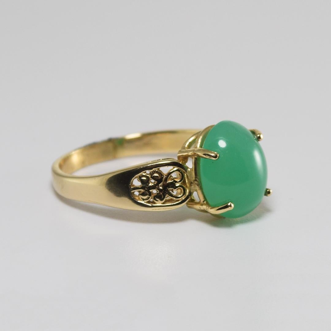 Ladies' ring in 14k yellow gold with chrysoprase.
Marked 14k and weighs 5.1 grams.
The cabochon cut green stone looks like an apple, green jade.
The stone is 4.50 carats and measures 12x10mm
The ring is 6.5mm wide at the top and 2.5mm wide at the