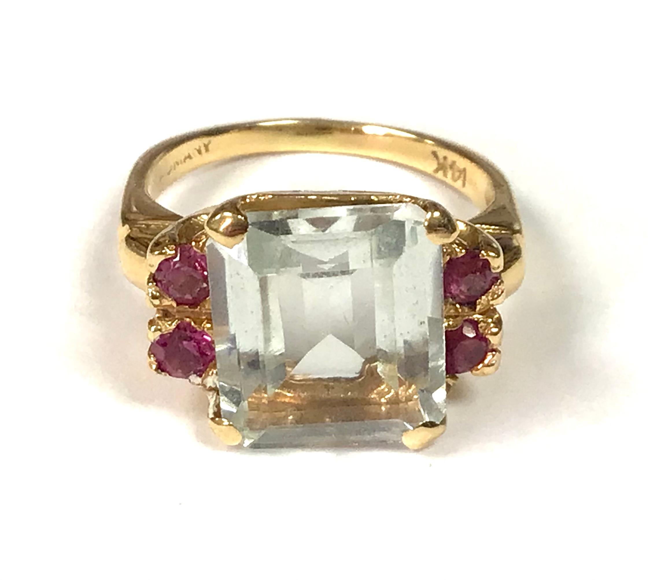 14K Yellow Gold, Aquamarine And Ruby Ring. Emerald cut aquamarine centered by four matching round pink rubies. Aquamarine approximately 5 carats. 