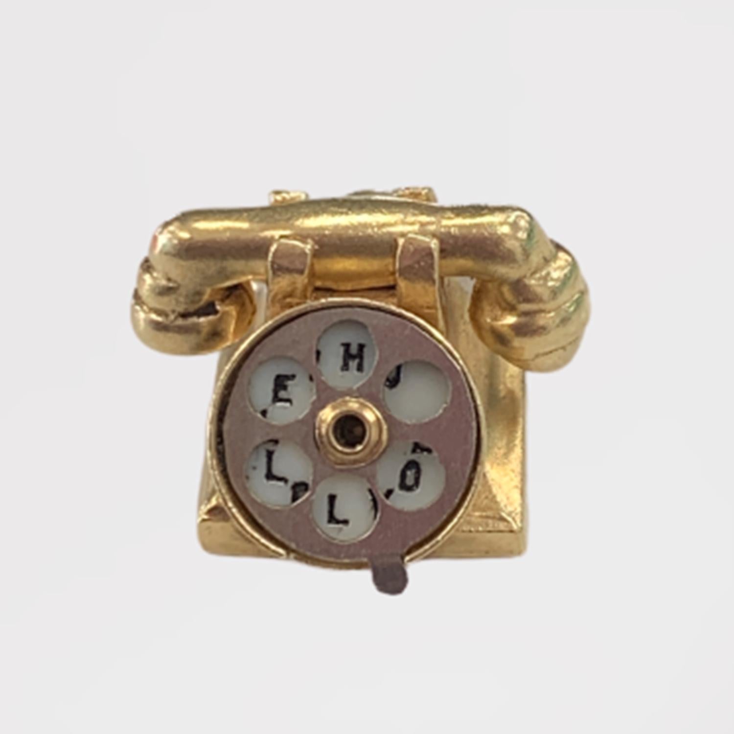 Vintage Rotary Telephone Charm circa 1930-40's

Crafted of solid 14K yellow gold, this lovely little telephone has some hidden secrets to share. The rotary dial actually rotates and shows two different messages depending on the position of the dial.