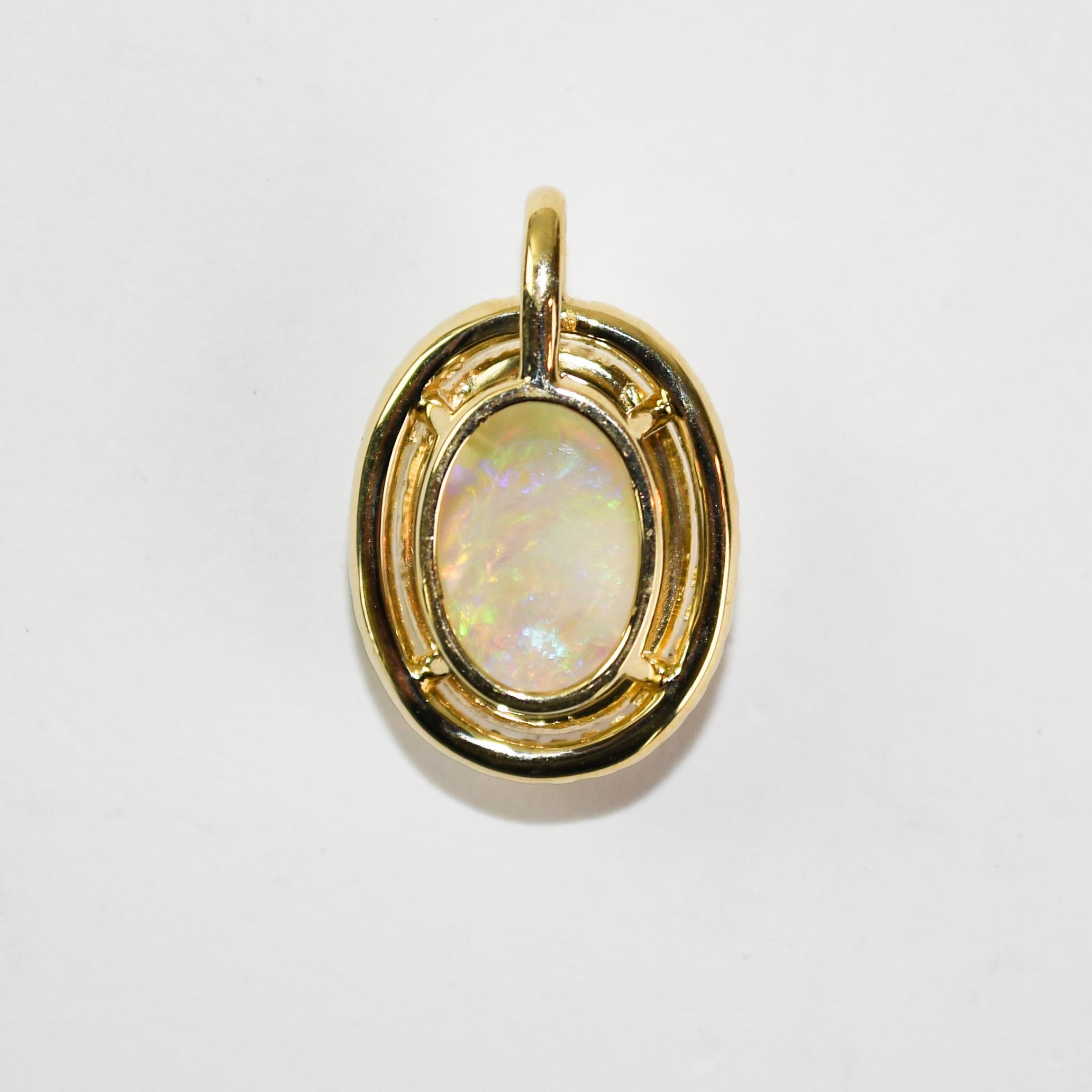 Pendente con opale australiano e diamante realizzato su misura con montatura in oro giallo 14k.
Il campione è stato analizzato al 59% con un analizzatore di metalli XRF. 
L'opale misura 14,5 mm x 11,5 mm x 5,7 mm, 5,20 carati.
Attraente e di alta