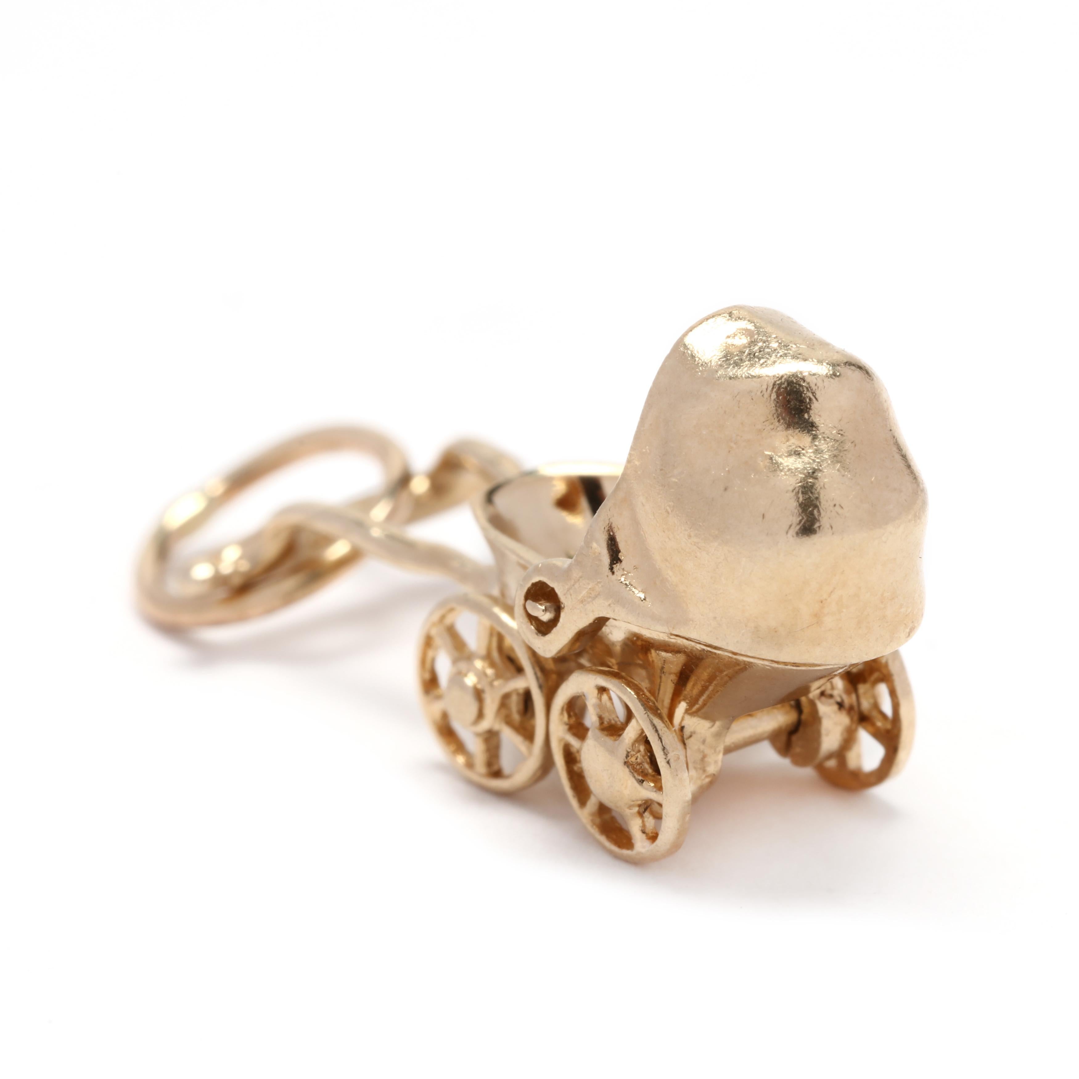 A vintage 14 karat yellow gold baby carriage charm. This charm features a vintage baby carriage motif with an articlated canopy and wheels.



Length: 15/16 in.



Width: 3/8 in.



Weight: 1.5 dwts.